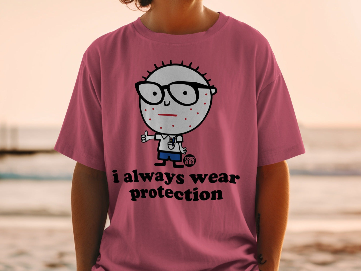 Pink t-shirt with cartoon character and "i always wear protection" text.