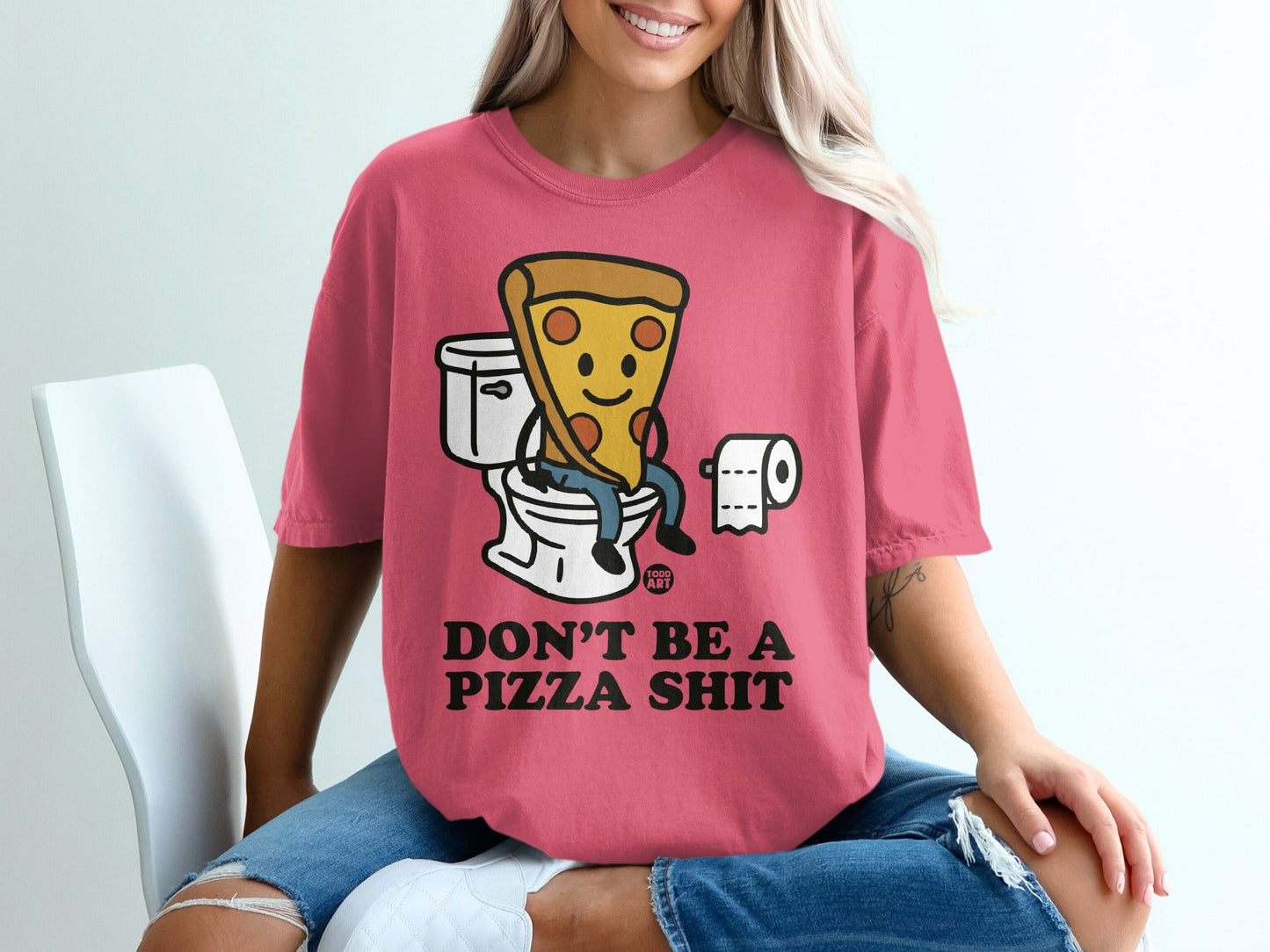 Pink t-shirt with cartoon pizza sitting on toilet and text "DON'T BE A PIZZA SHIT".