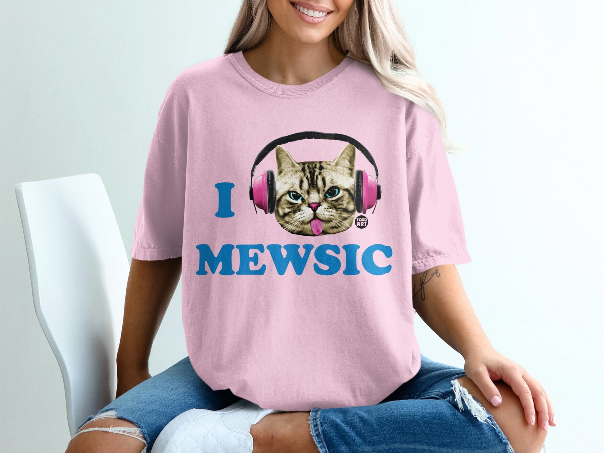 Pink t-shirt with "I MEWSIC" text and headphones on a cat graphic.