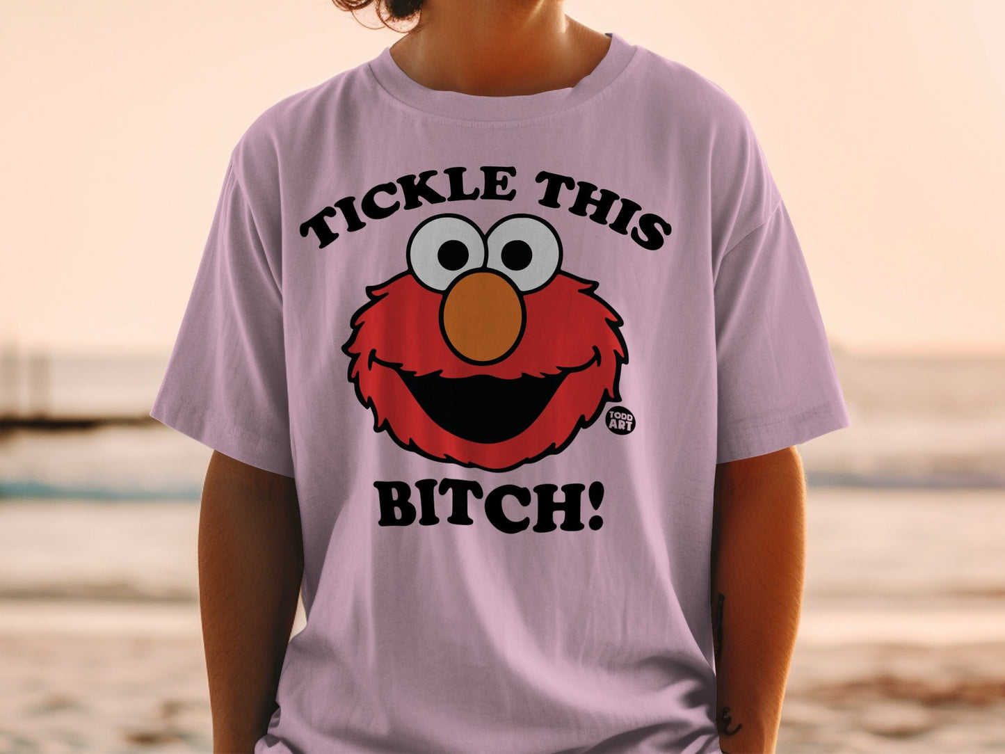 Pink t-shirt with Elmo face and "TICKLE THIS BITCH!" text.