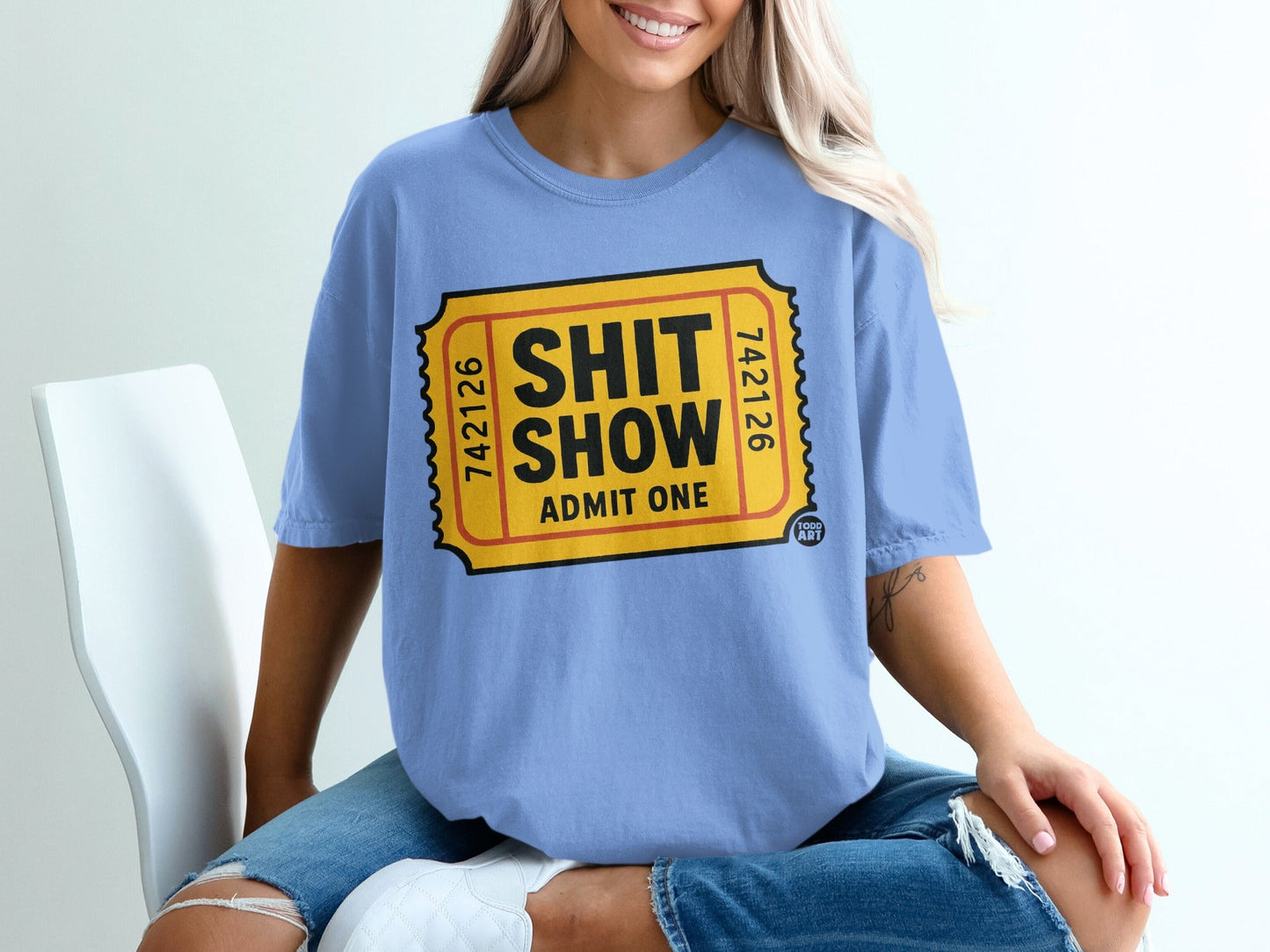 Blue t-shirt with yellow "Shit Show Admit One" ticket design.