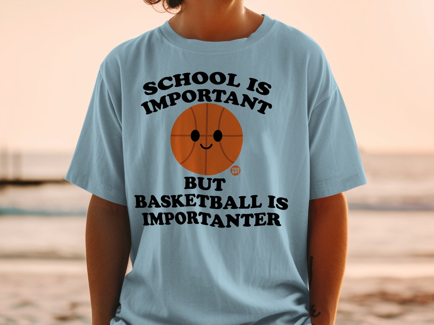 Light blue t-shirt with "School is important but basketball is importanter" text.
