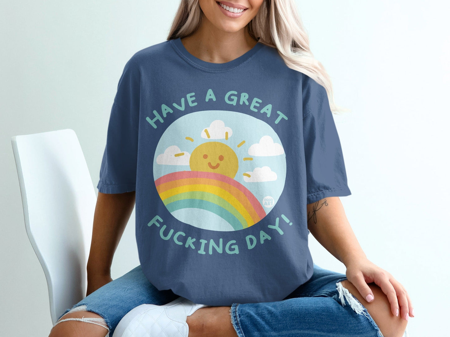 Blue t-shirt with a smiling sun, rainbow, and text "HAVE A GREAT FUCKING DAY!".