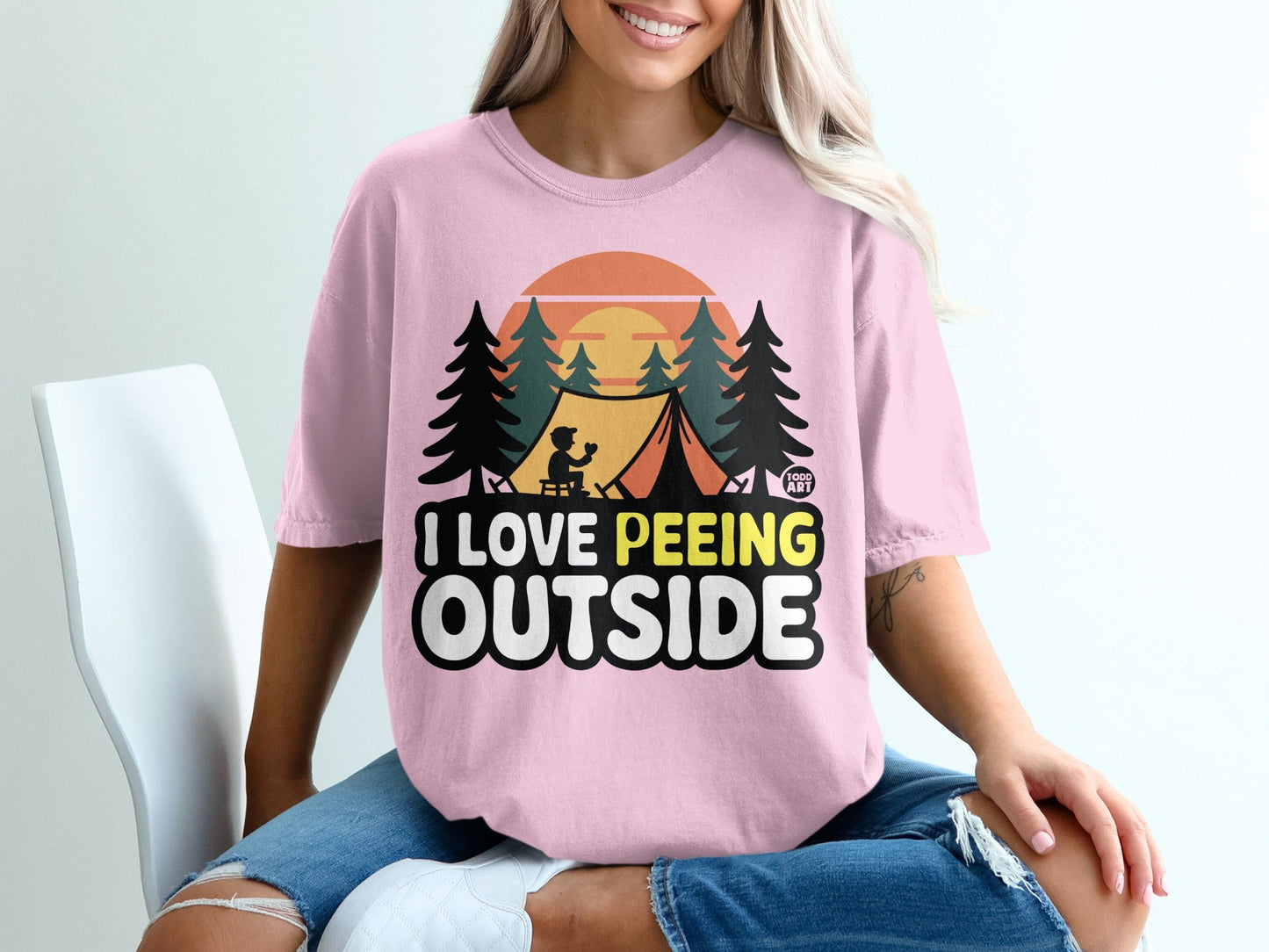 Pink t-shirt with "I love peeing outside" graphic featuring a tent and trees.