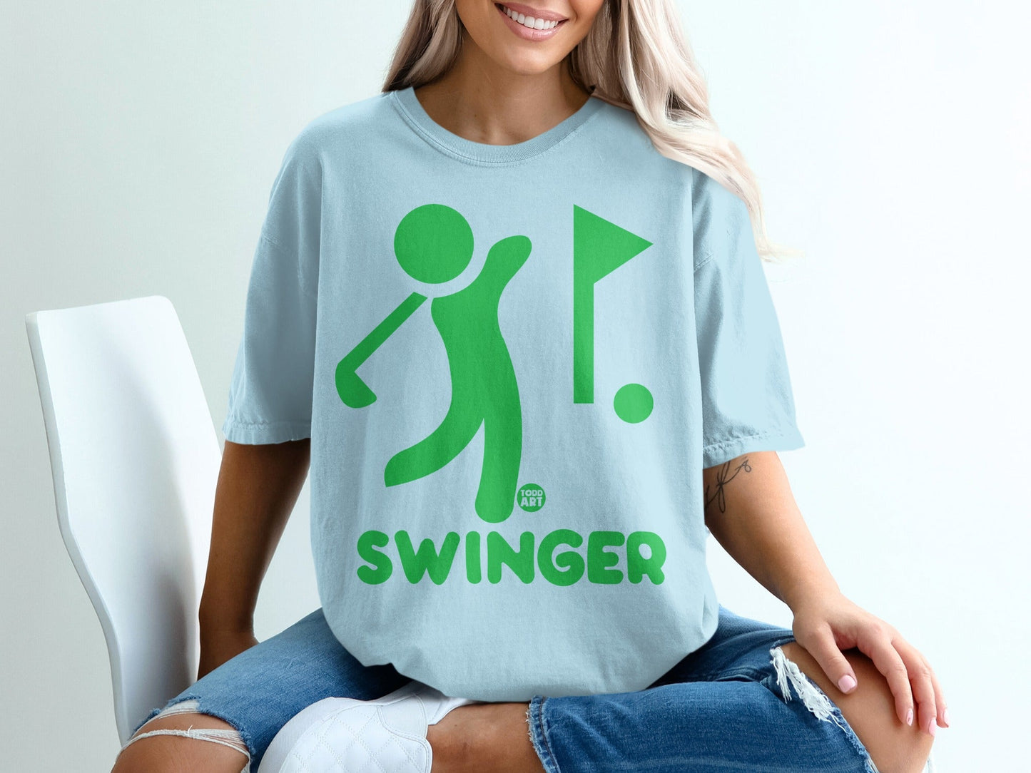Light blue t-shirt with green golf graphic and "SWINGER" text.