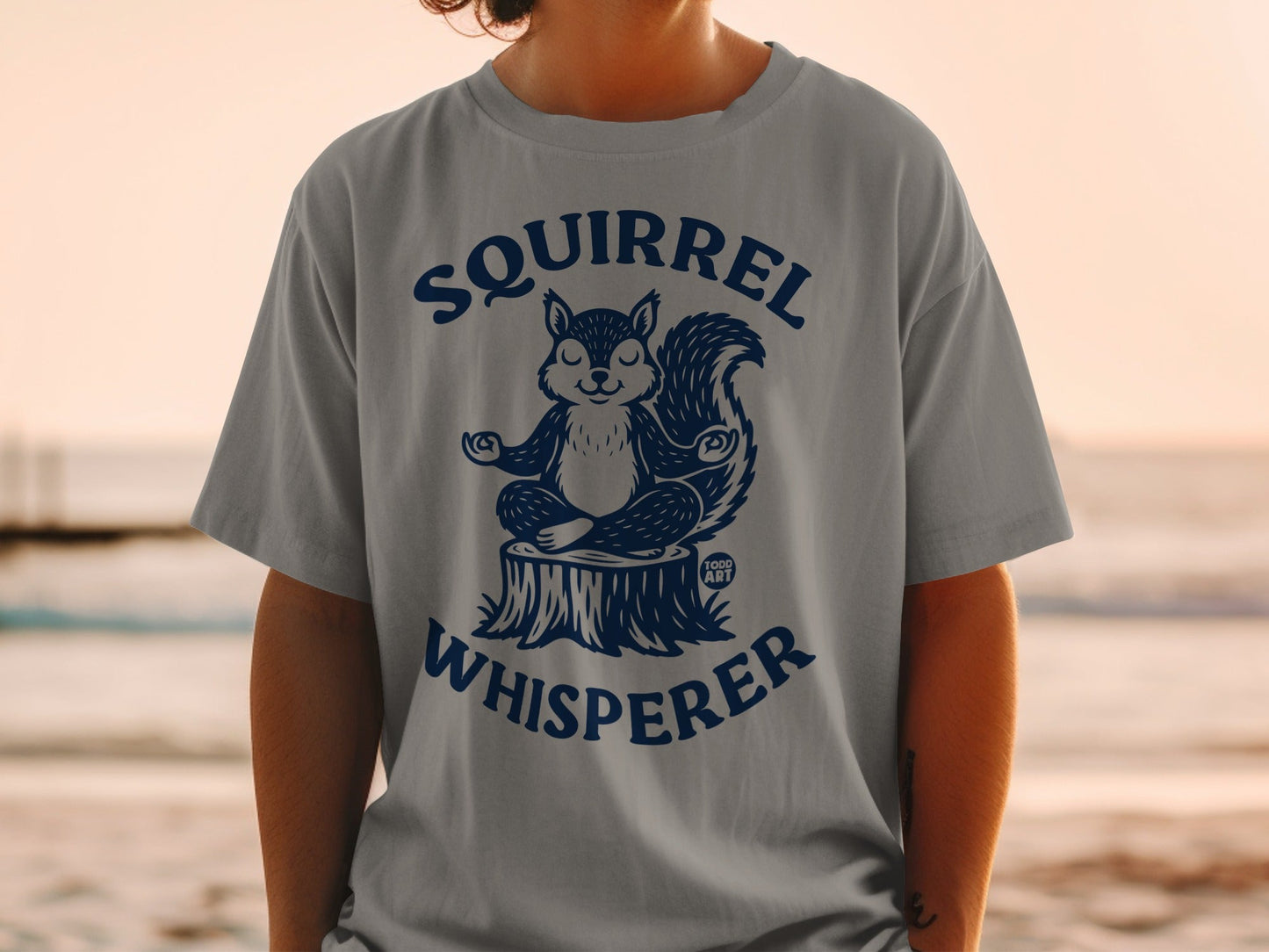 T-shirt with a meditating squirrel graphic and "Squirrel Whisperer" text.