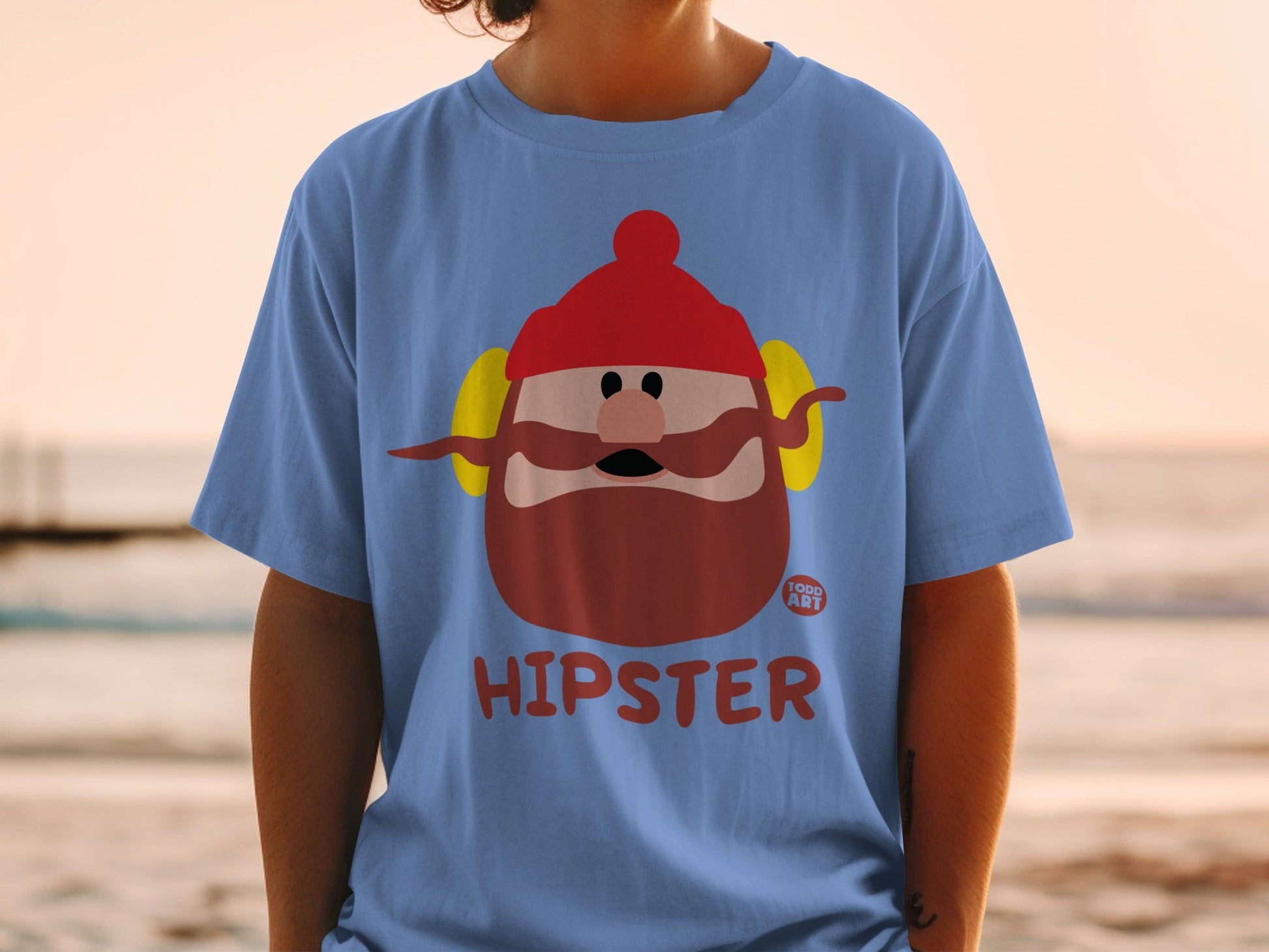 Blue t-shirt with cartoon hipster character wearing red hat and earmuffs.