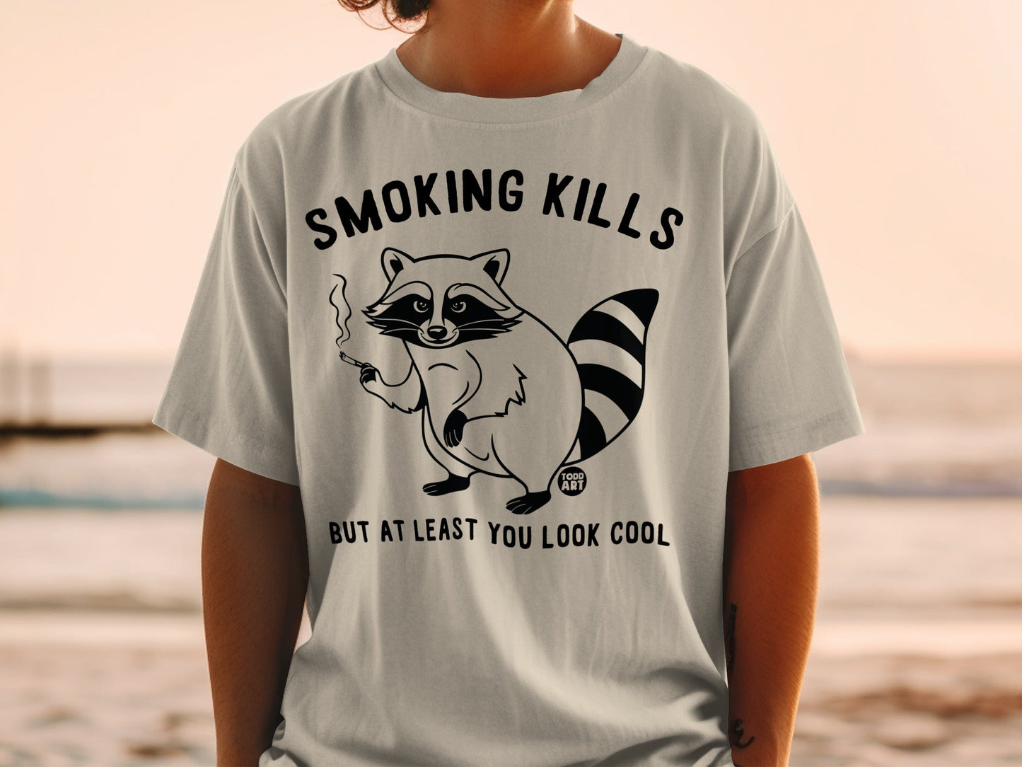 T-shirt with raccoon smoking and text "SMOKING KILLS BUT AT LEAST YOU LOOK COOL".