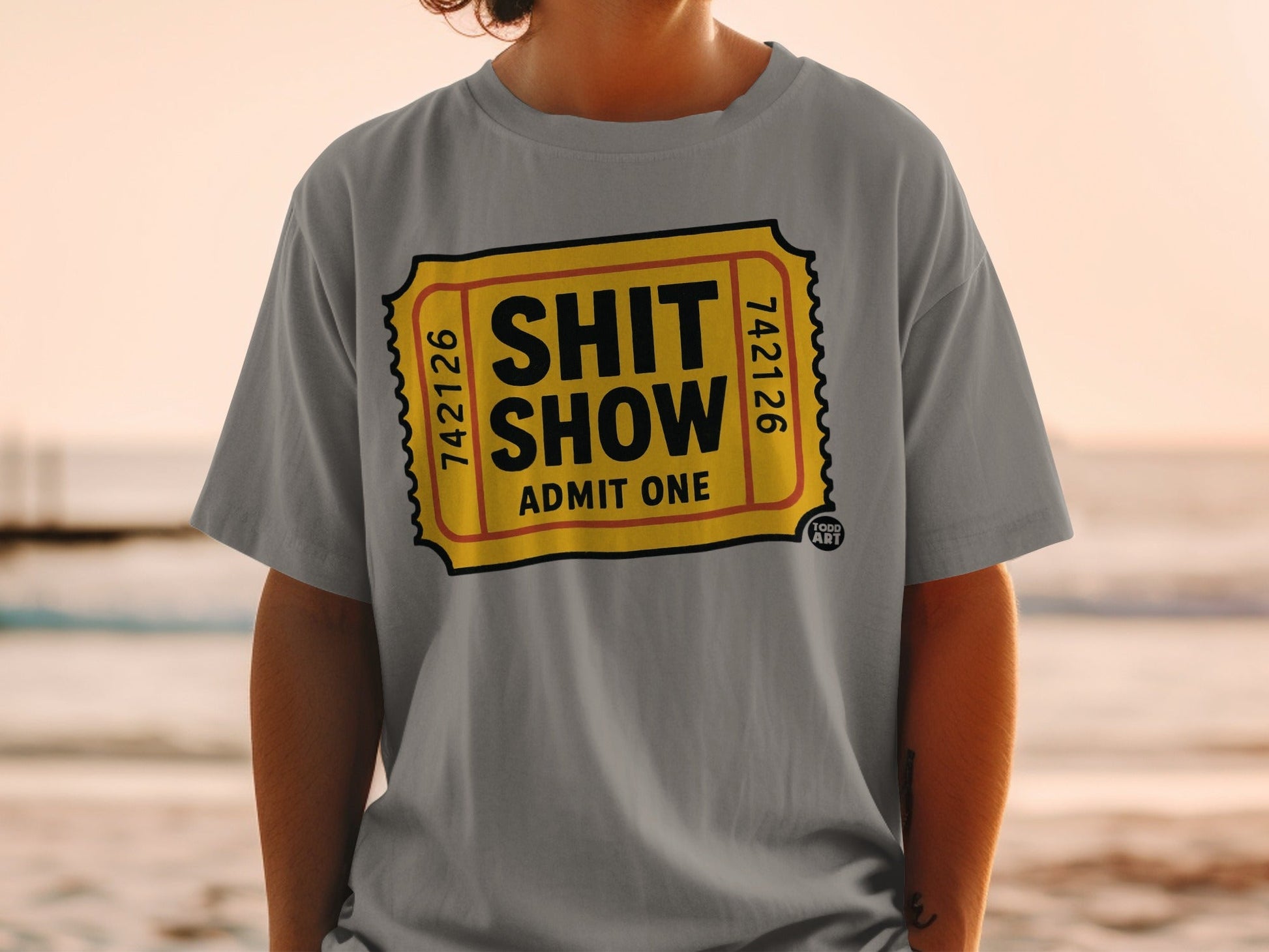 Grey t-shirt with a yellow ticket graphic reading "SHIT SHOW ADMIT ONE".