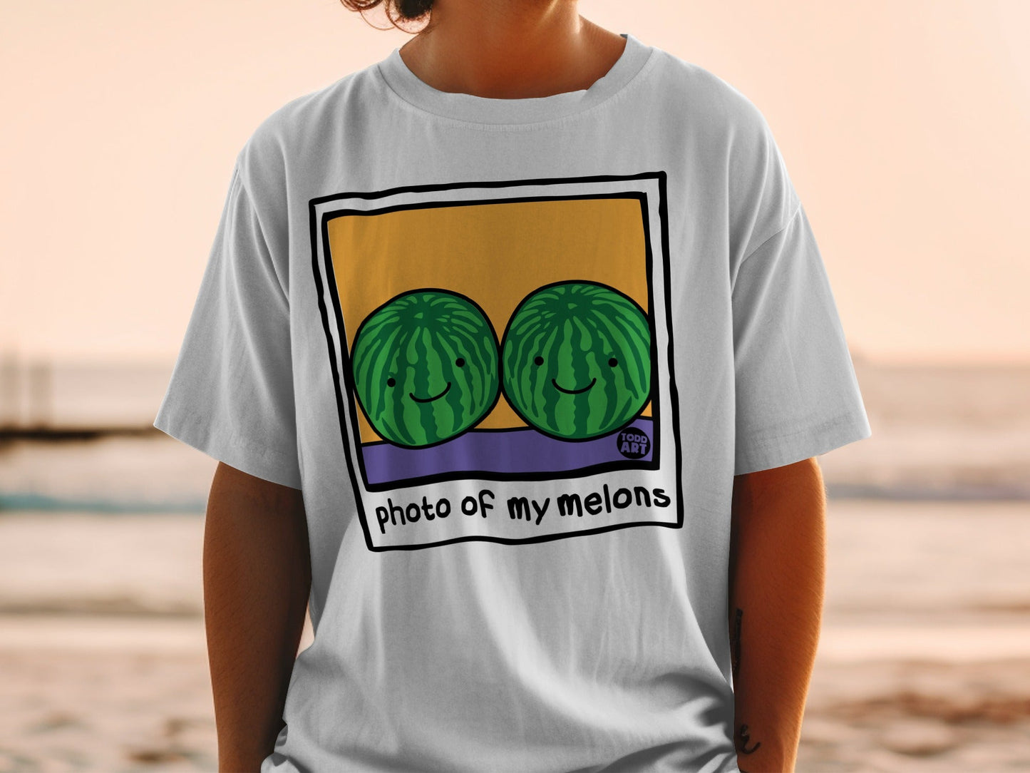 T-shirt with a framed illustration of two smiling watermelons and text "photo of my melons".