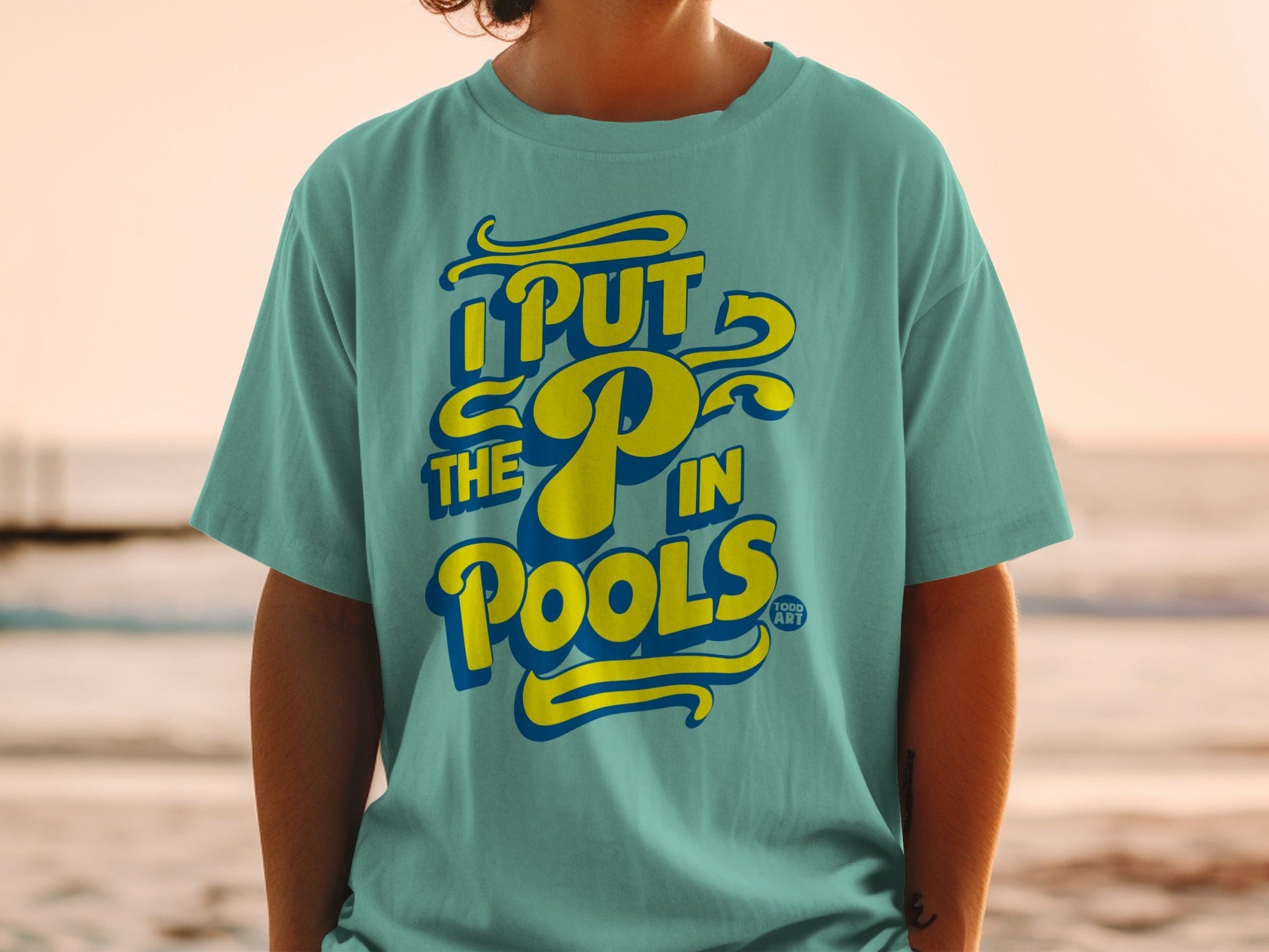 Teal t-shirt with yellow "I PUT THE P in POOLS" text, with a small art logo.