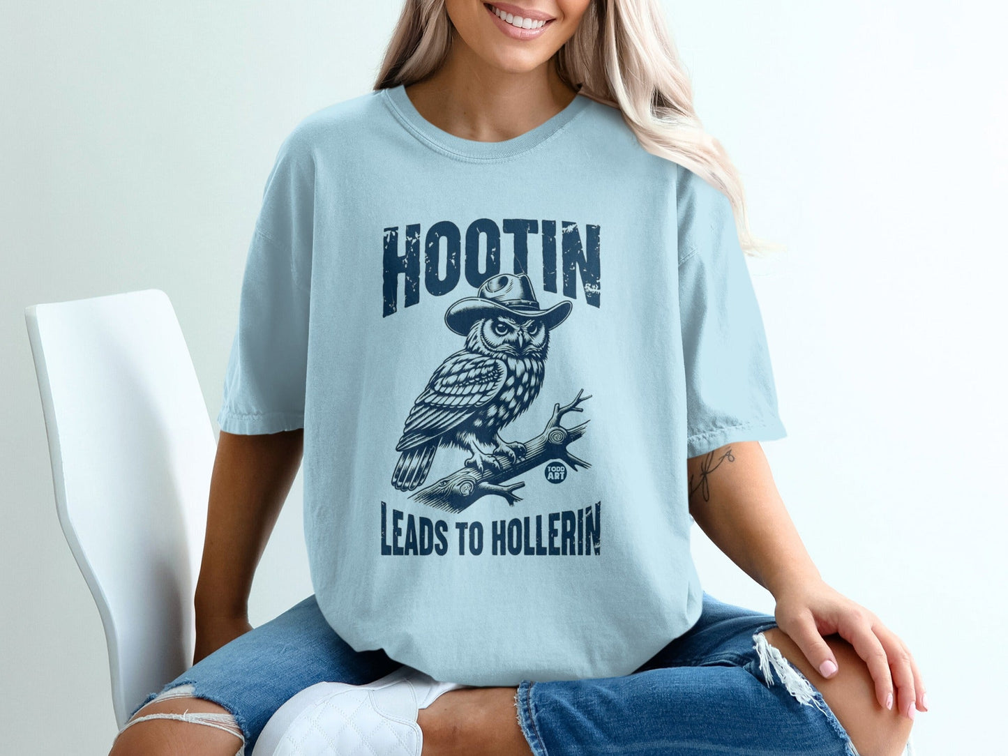 Light blue t-shirt with owl in cowboy hat and text "HOOTIN' LEADS TO HOLLERIN'".