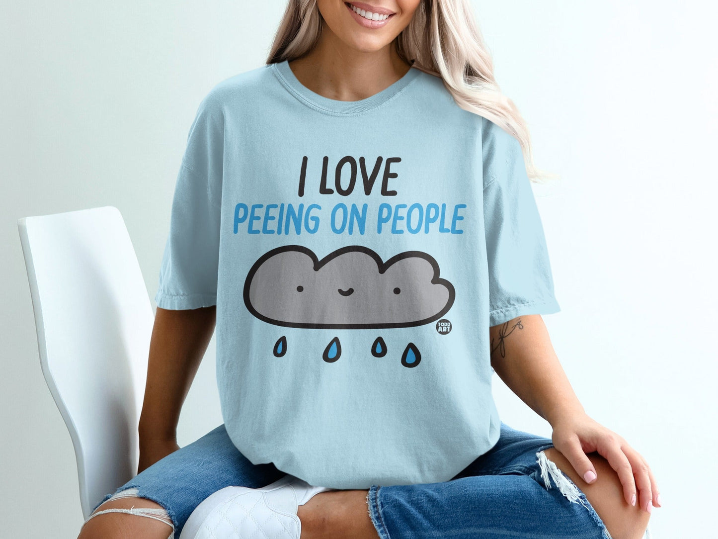 Light blue t-shirt with cartoon cloud and text "I LOVE PEEING ON PEOPLE".