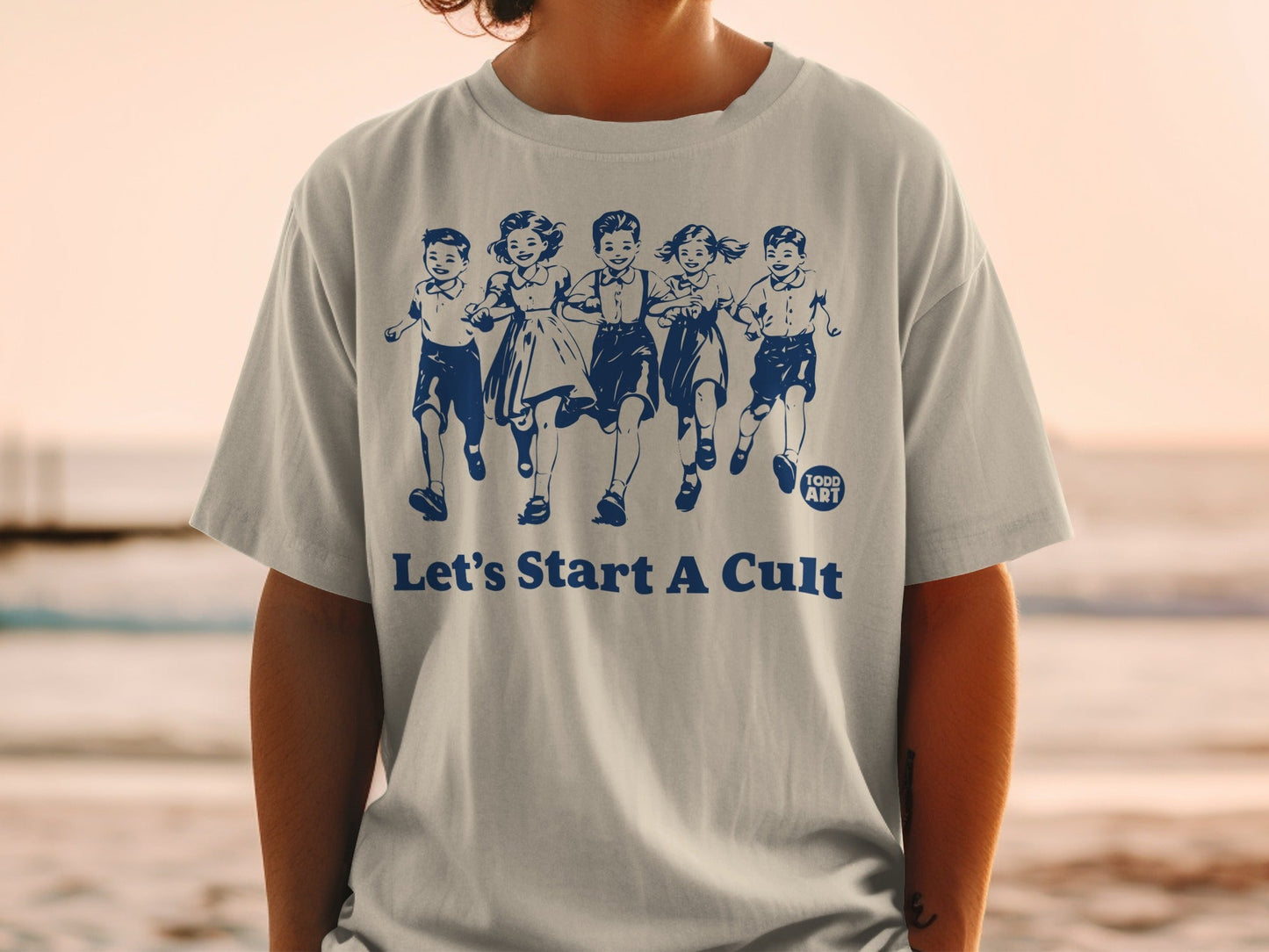 T-shirt with children running and text "Let's Start A Cult" and "TODD ART".