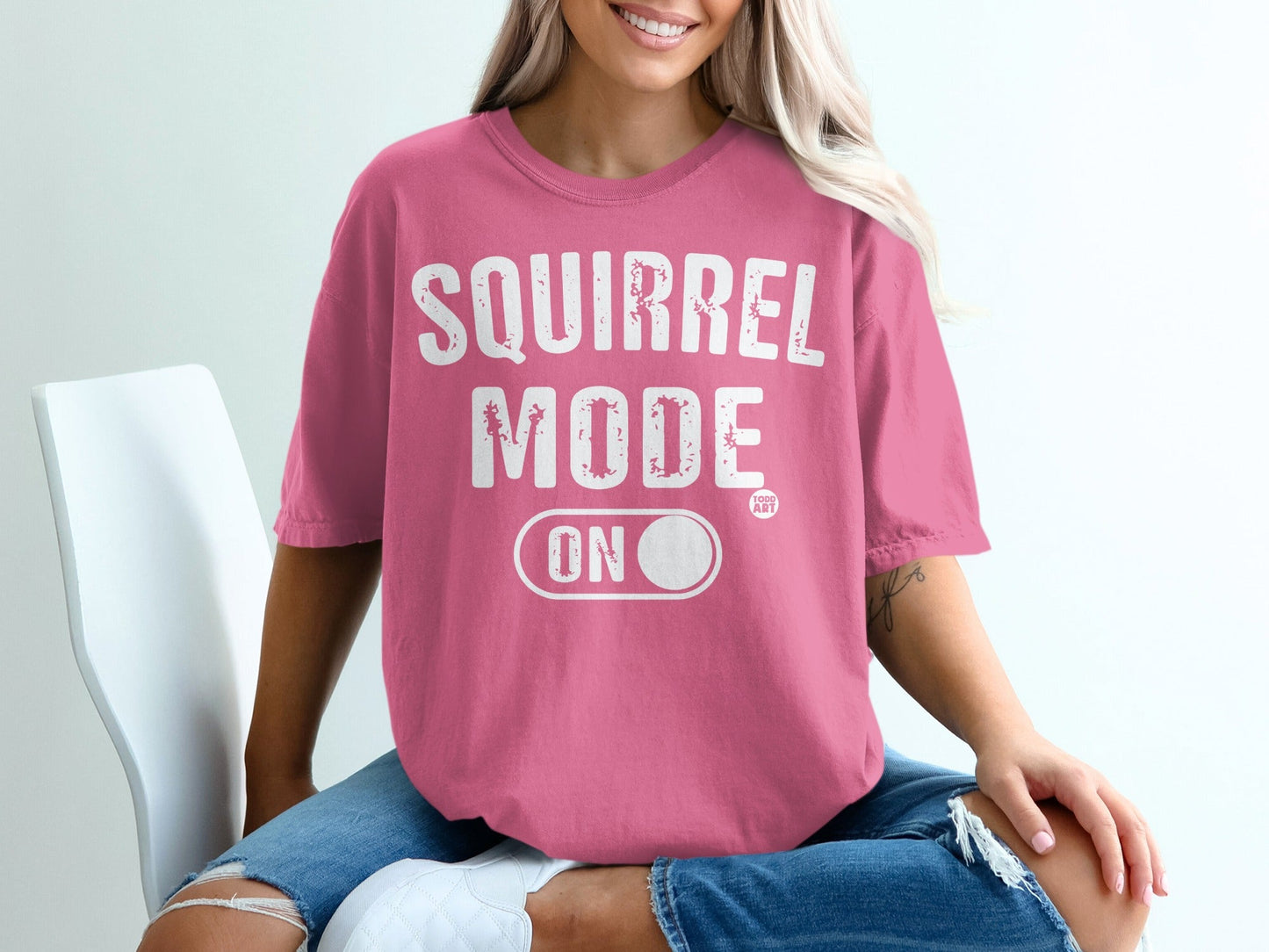 Pink t-shirt with "SQUIRREL MODE ON" text and small circular graphic.