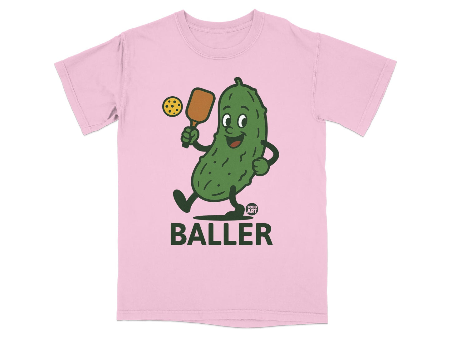 Pink t-shirt with cartoon pickle playing pickleball, text "BALLER".
