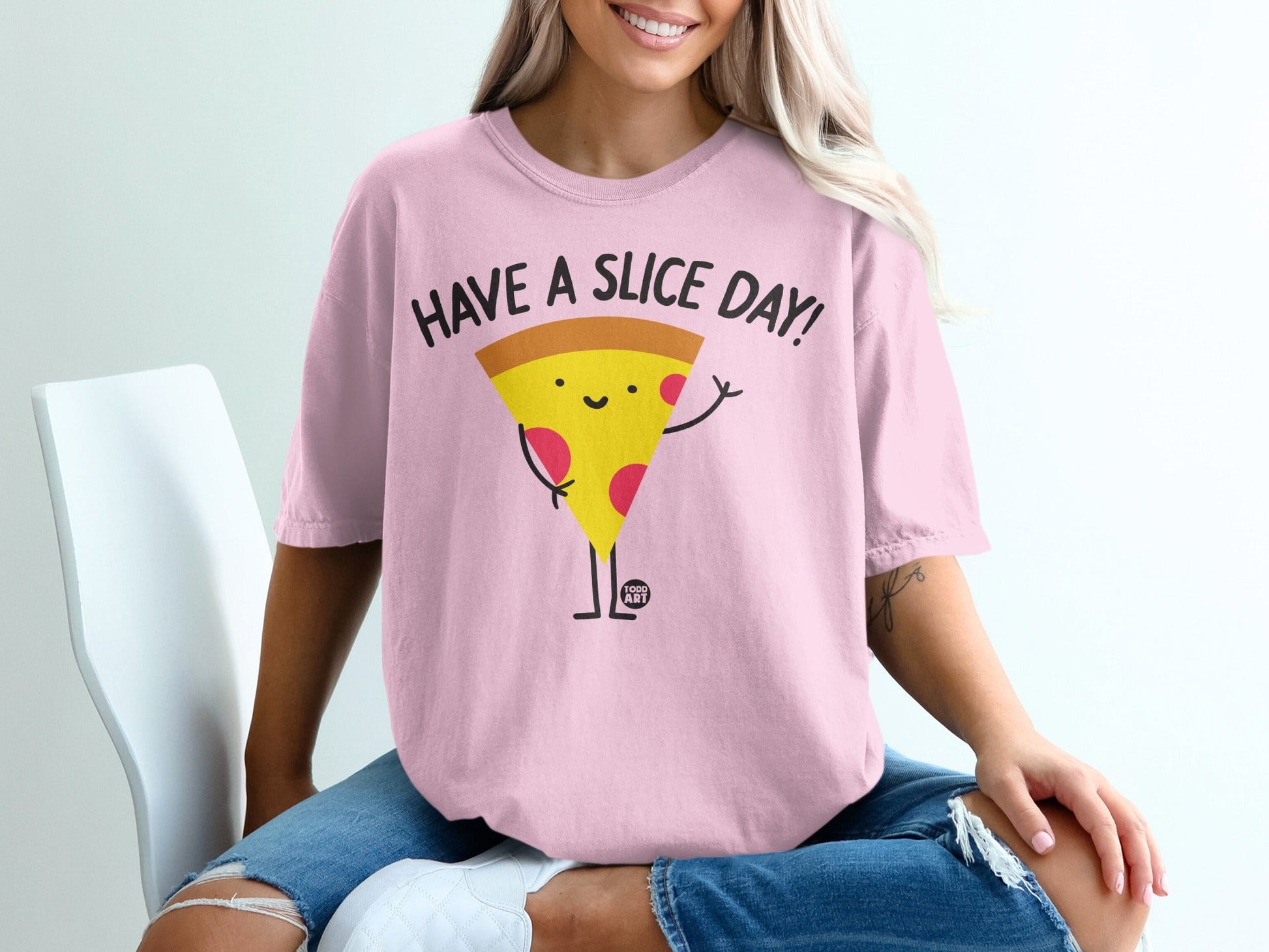 Pink t-shirt with a cartoon slice of pizza that says "Have a Slice Day!"