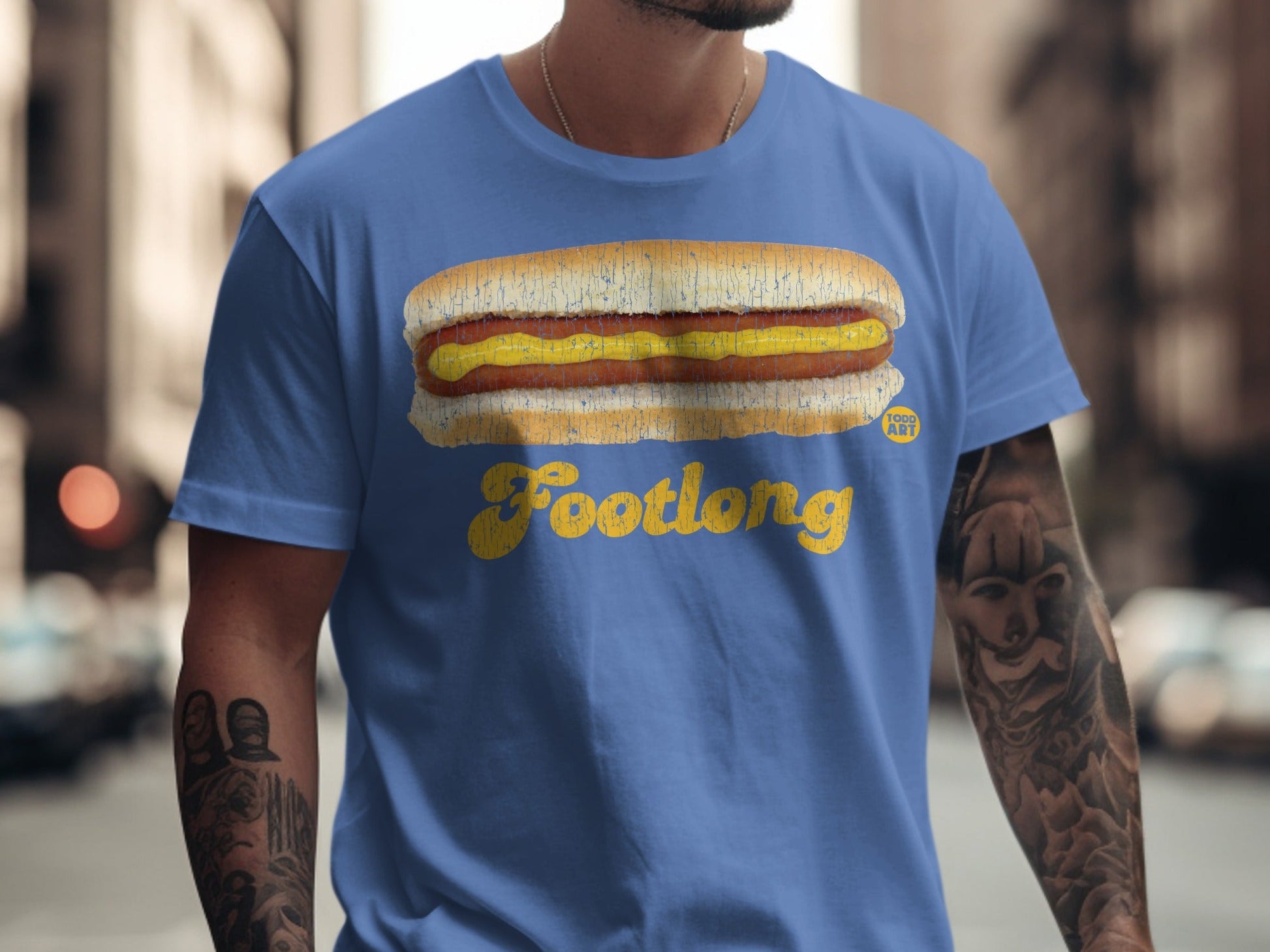 Blue t-shirt with a yellow hot dog and "Footlong" text.