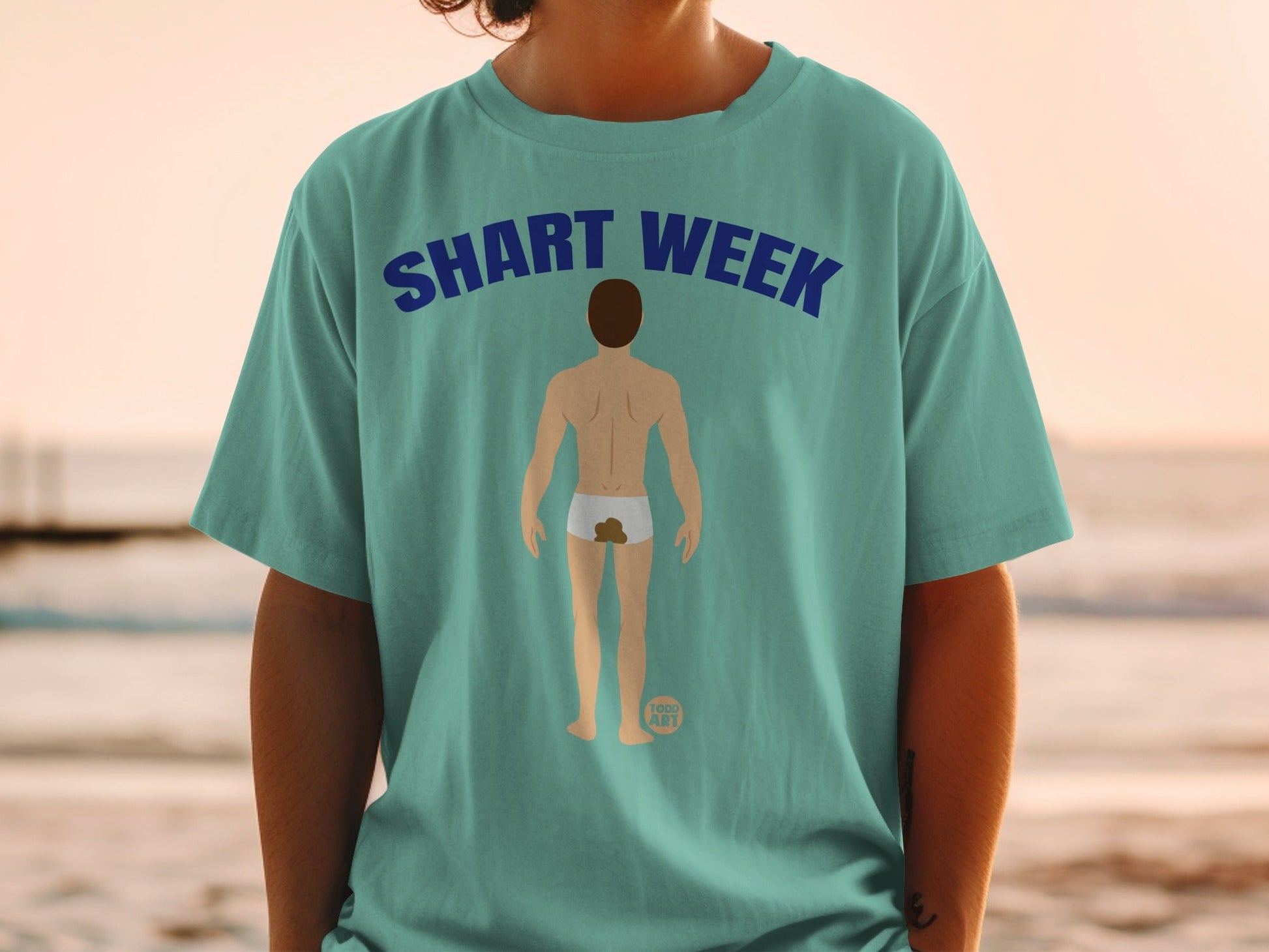 Teal t-shirt with "SHART WEEK" text and a cartoon butt with a brown stain.