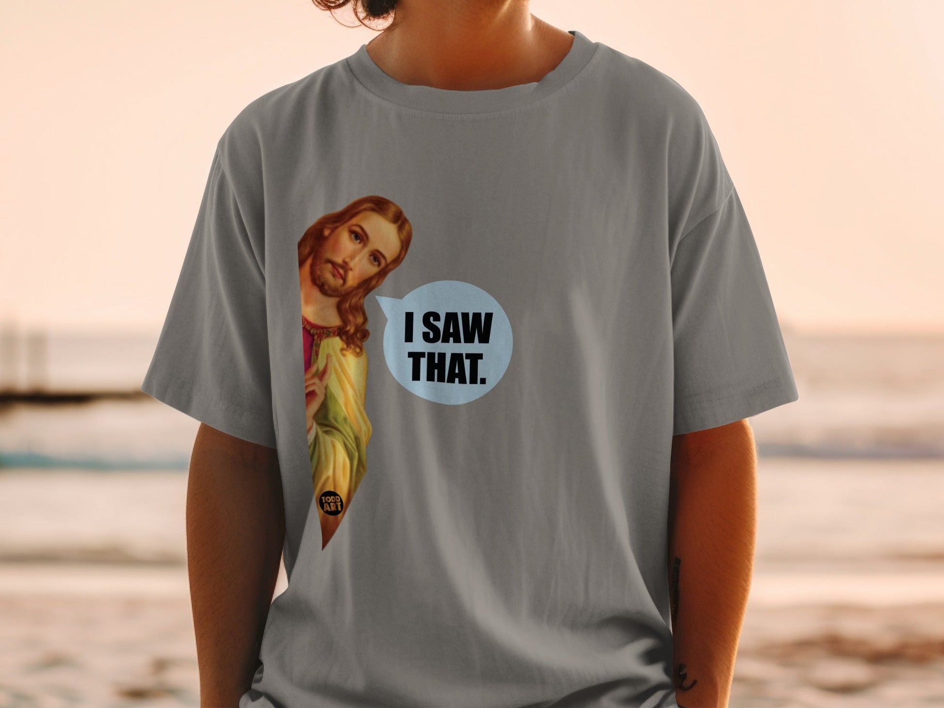 Grey t-shirt with Jesus peeking out saying "I saw that."