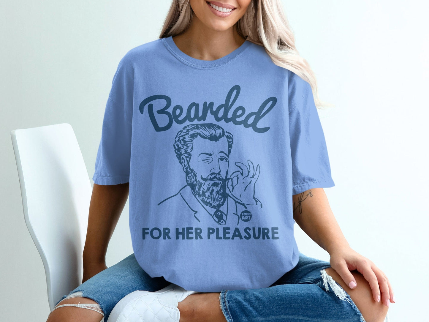 Blue t-shirt with "Bearded for Her Pleasure" graphic and man winking.