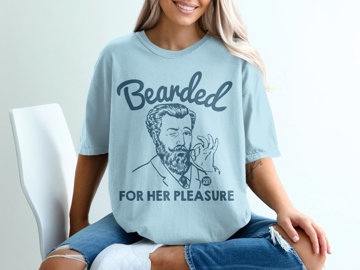 Light blue t-shirt with "Bearded for her pleasure" text and man winking.