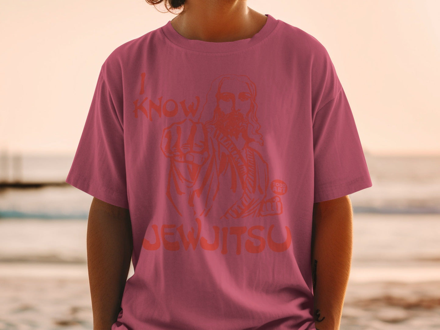 Pink t-shirt with orange graphic of Jesus pointing and text "I KNOW JEW JITSU".