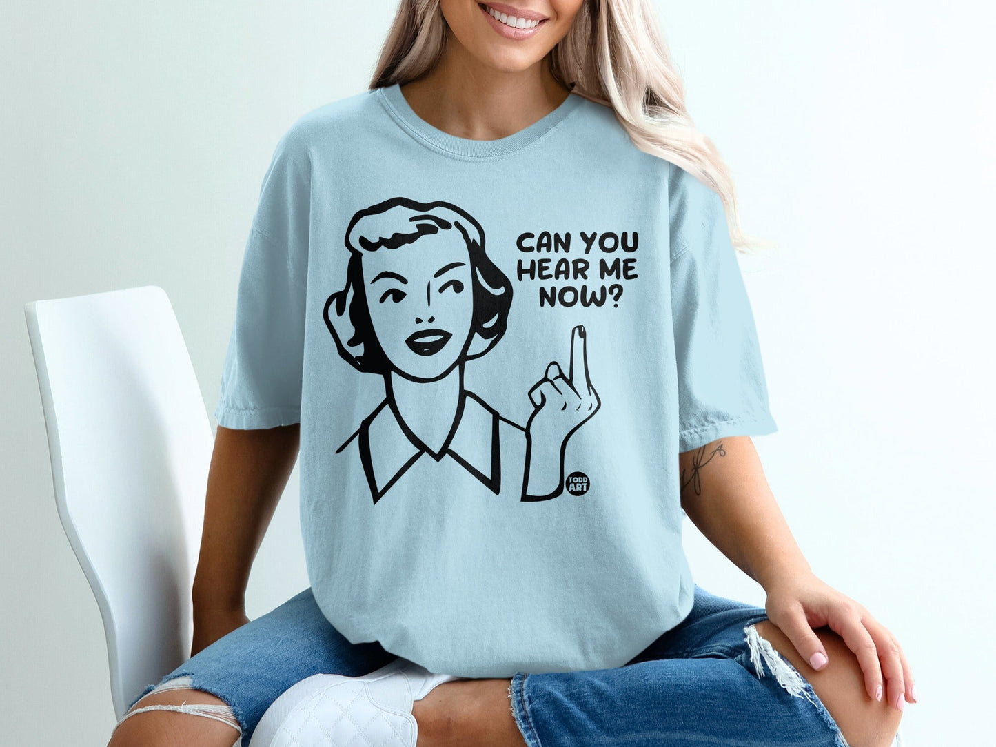 Light blue t-shirt with graphic of a woman pointing up and text "CAN YOU HEAR ME NOW?".