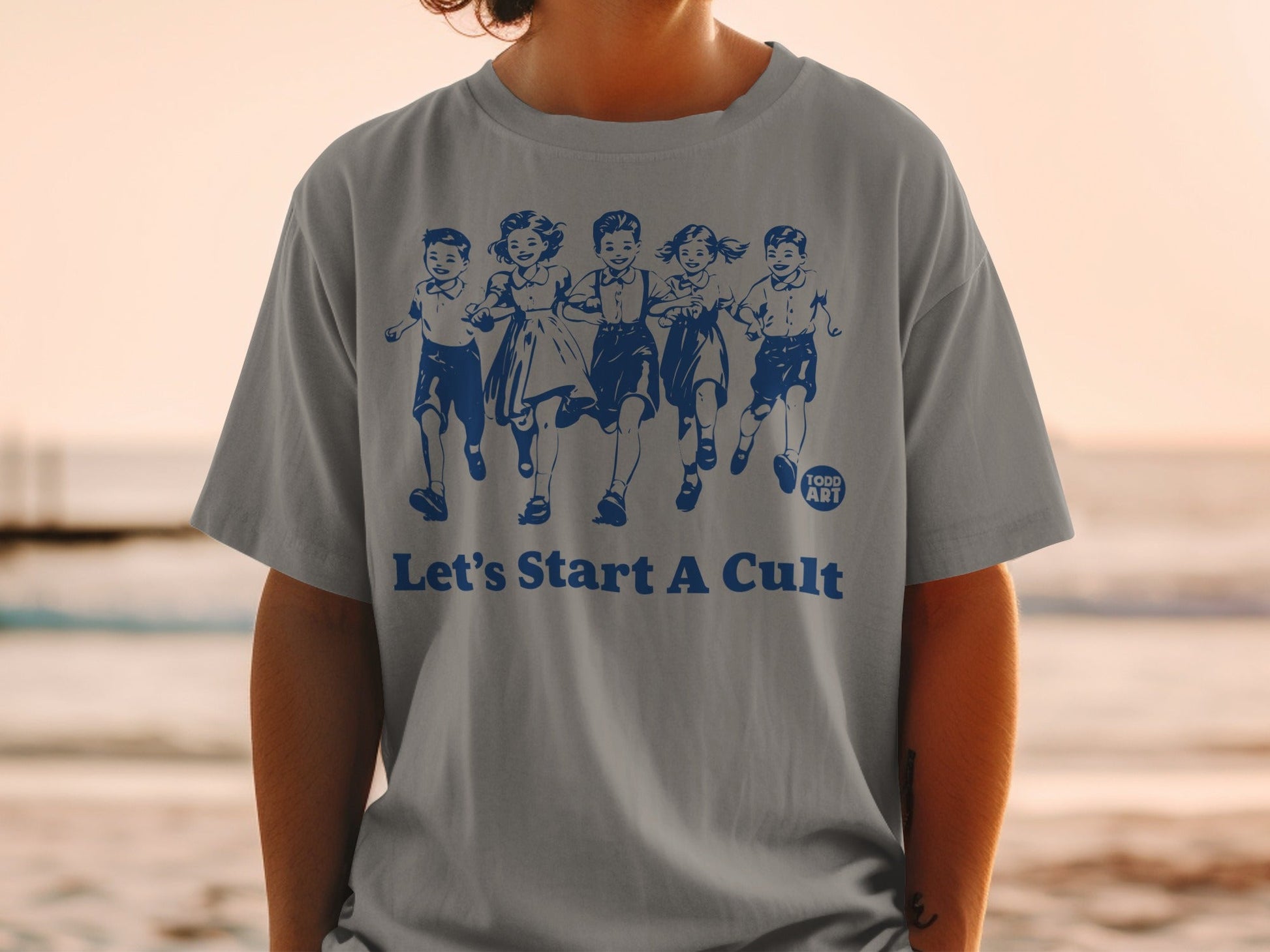 Grey t-shirt with "Let's Start A Cult" and children running.