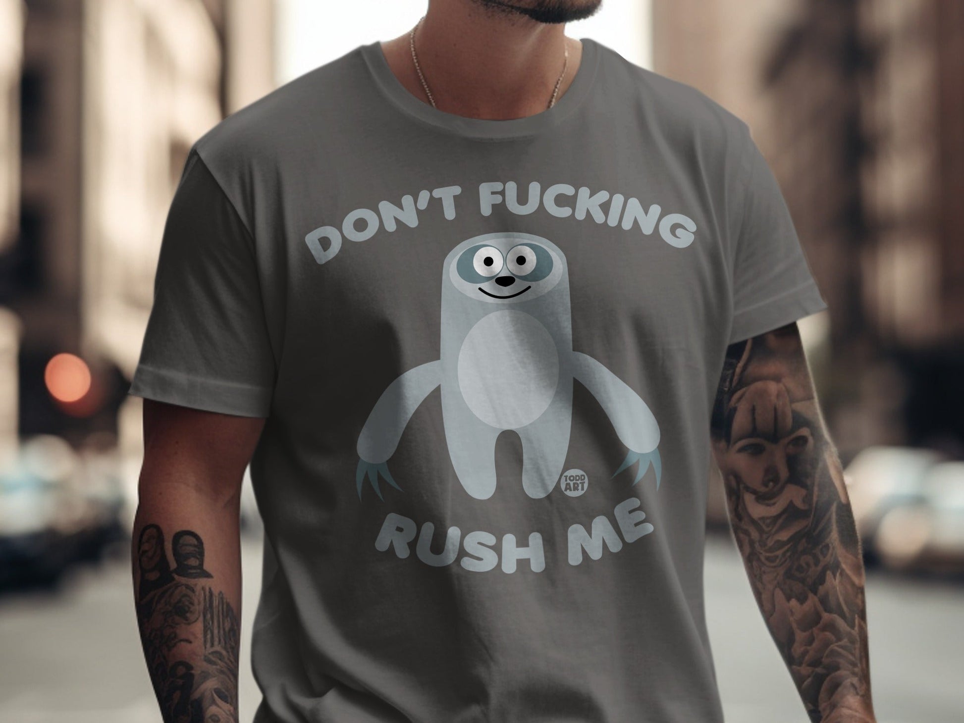 Gray t-shirt with a cartoon sloth saying "Don't Fucking Rush Me".