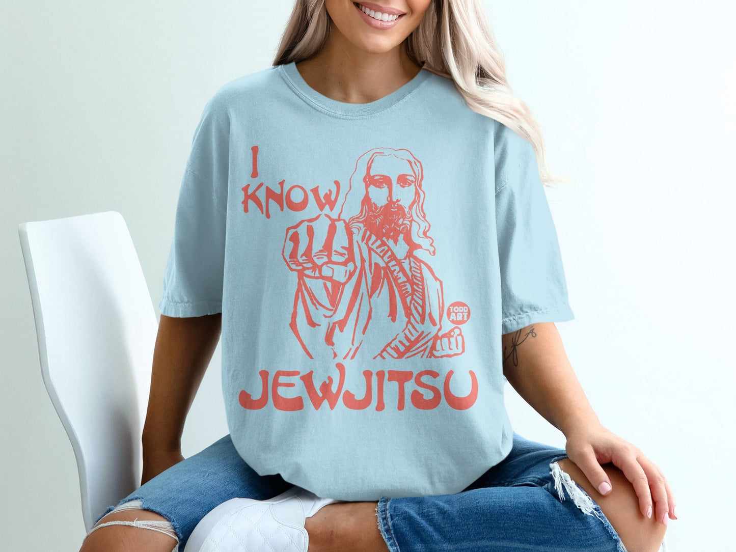 Light blue t-shirt with red graphic of Jesus pointing and text "I KNOW JEWJITSU".