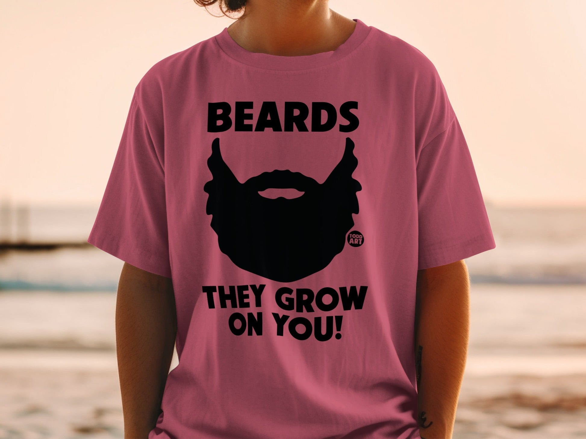 Pink t-shirt with black beard graphic and "BEARDS THEY GROW ON YOU!" text.