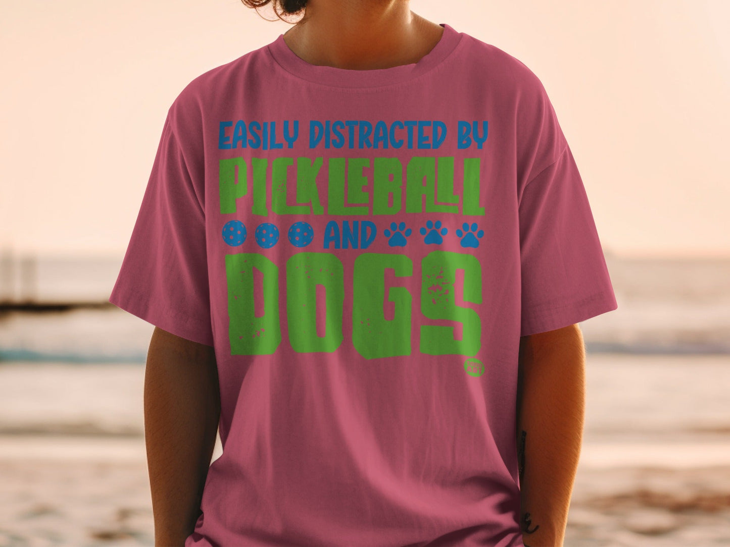 Pink t-shirt with "Easily Distracted by Pickleball and Dogs" text.