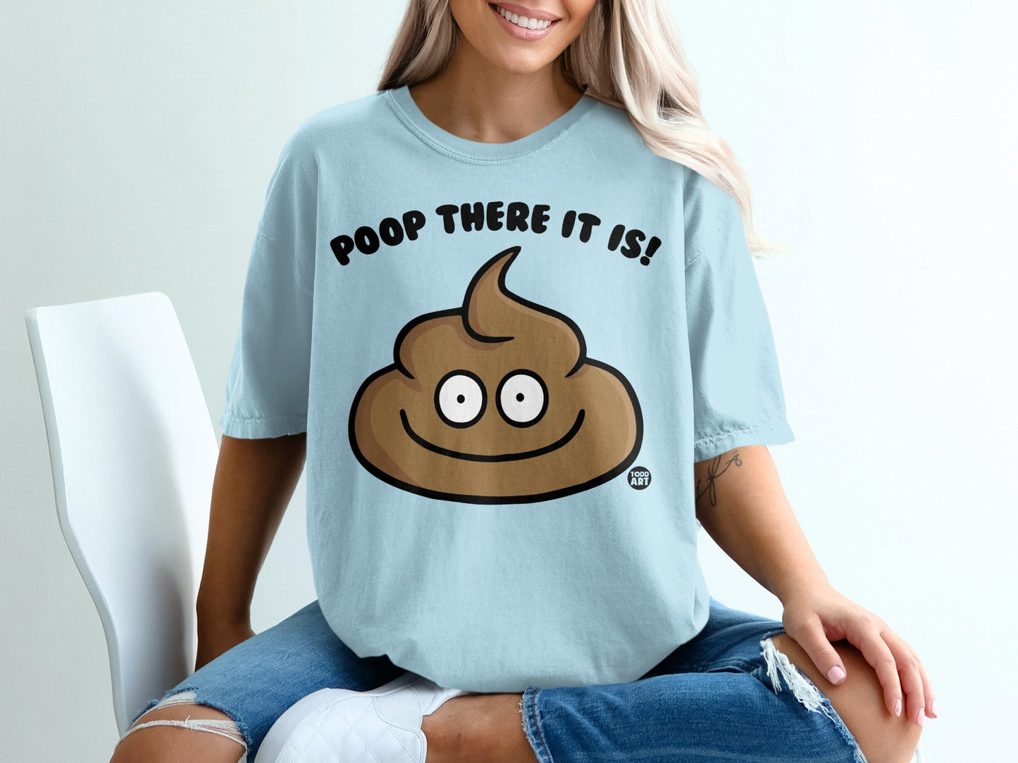 Light blue t-shirt with a smiling cartoon poop character and "POOP THERE IT IS!" text.