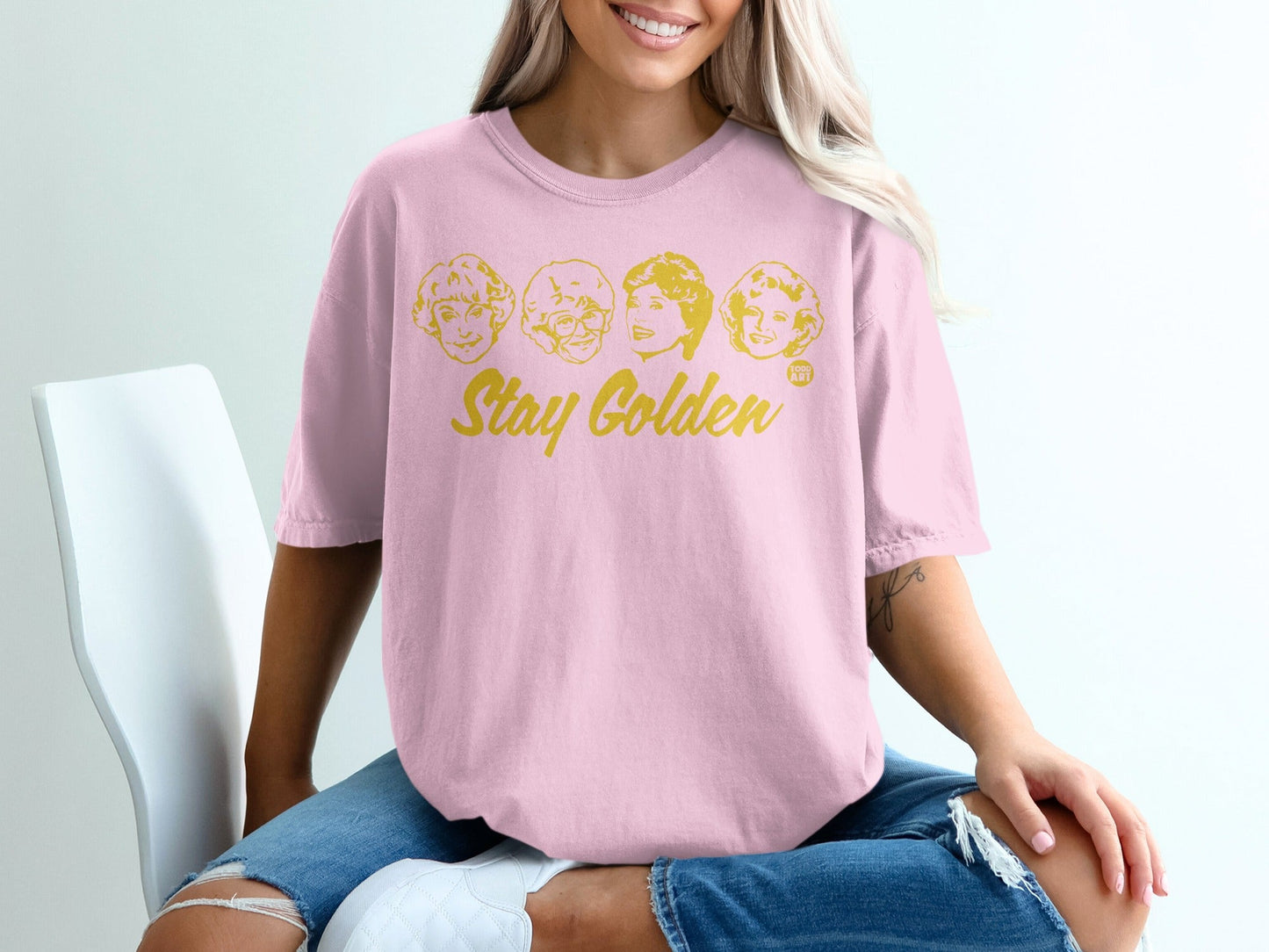 Pink t-shirt with "Stay Golden" and four cartoon faces.