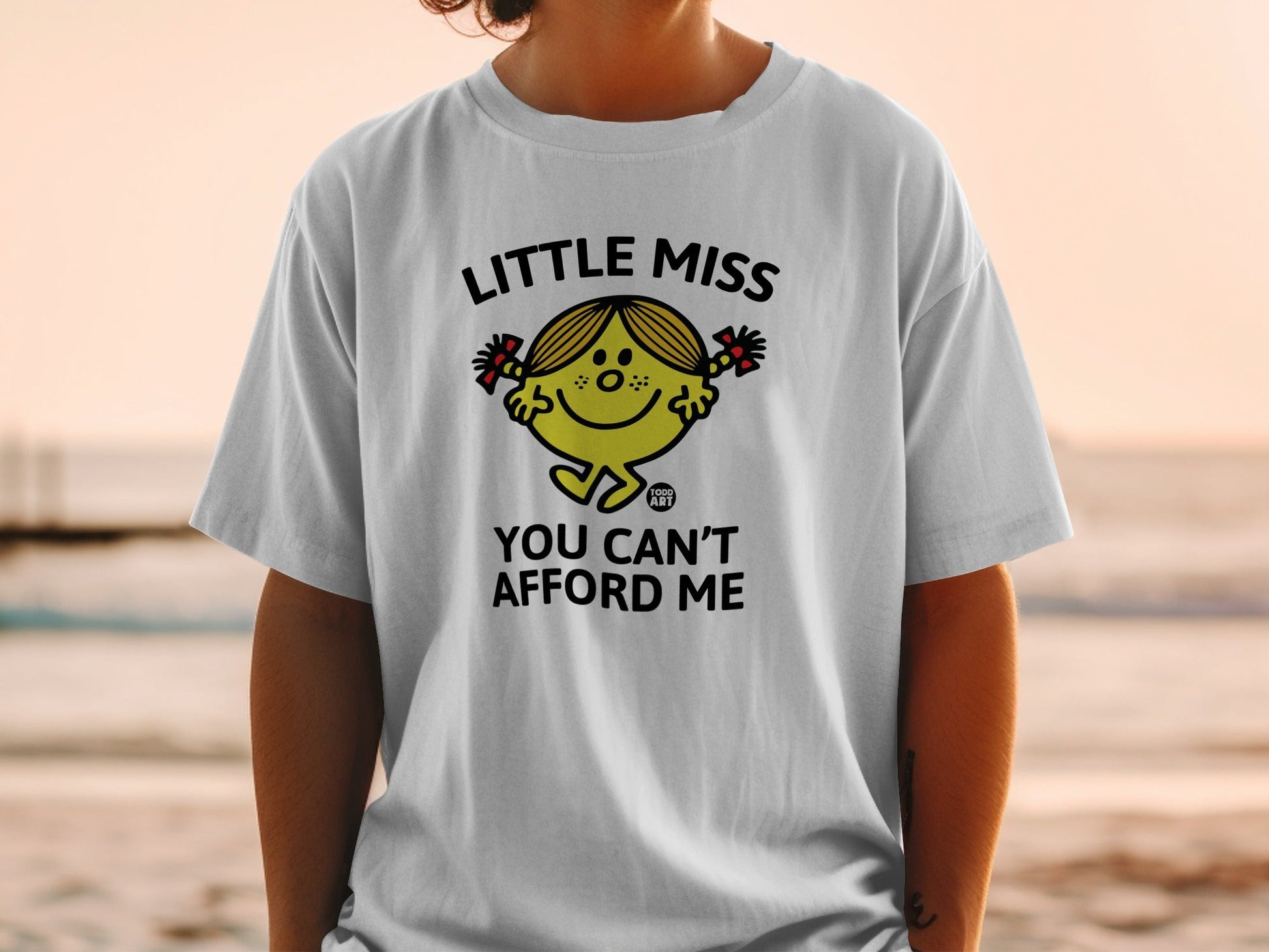 White t-shirt with "Little Miss You Can't Afford Me" and cartoon character.