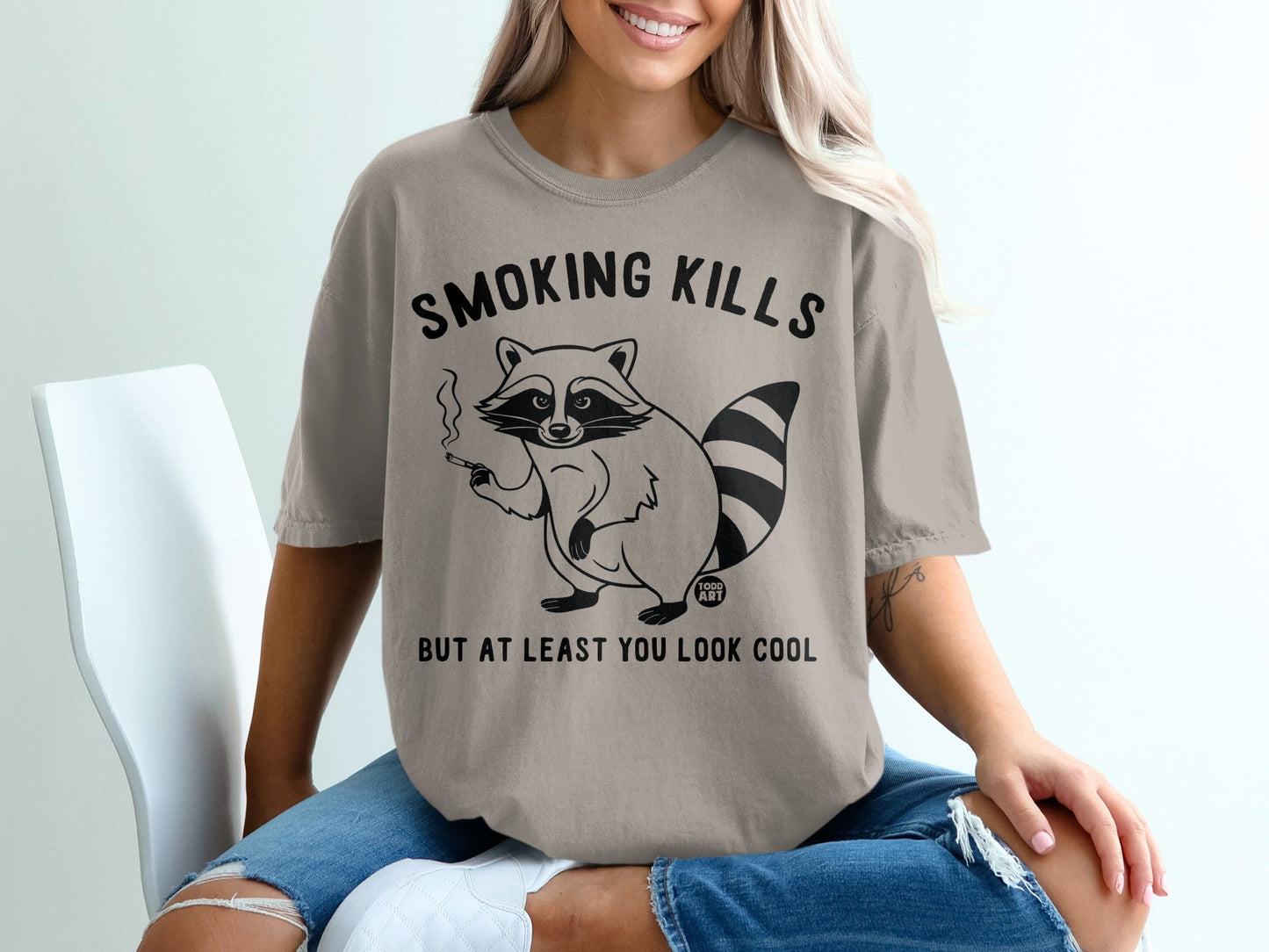 T-shirt with raccoon smoking, text "SMOKING KILLS BUT AT LEAST YOU LOOK COOL".