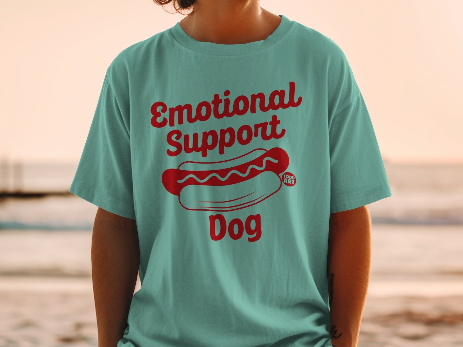 Teal t-shirt with red text "Emotional Support Dog" and hot dog graphic.