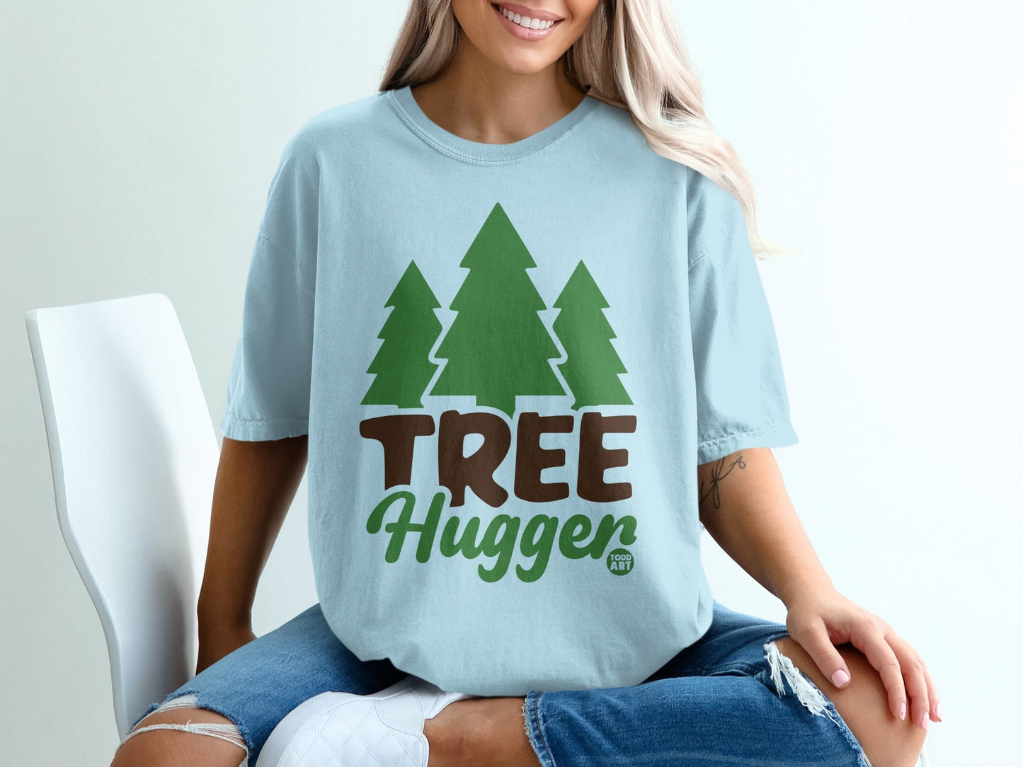 Light blue t-shirt with green trees and "Tree Hugger" text.