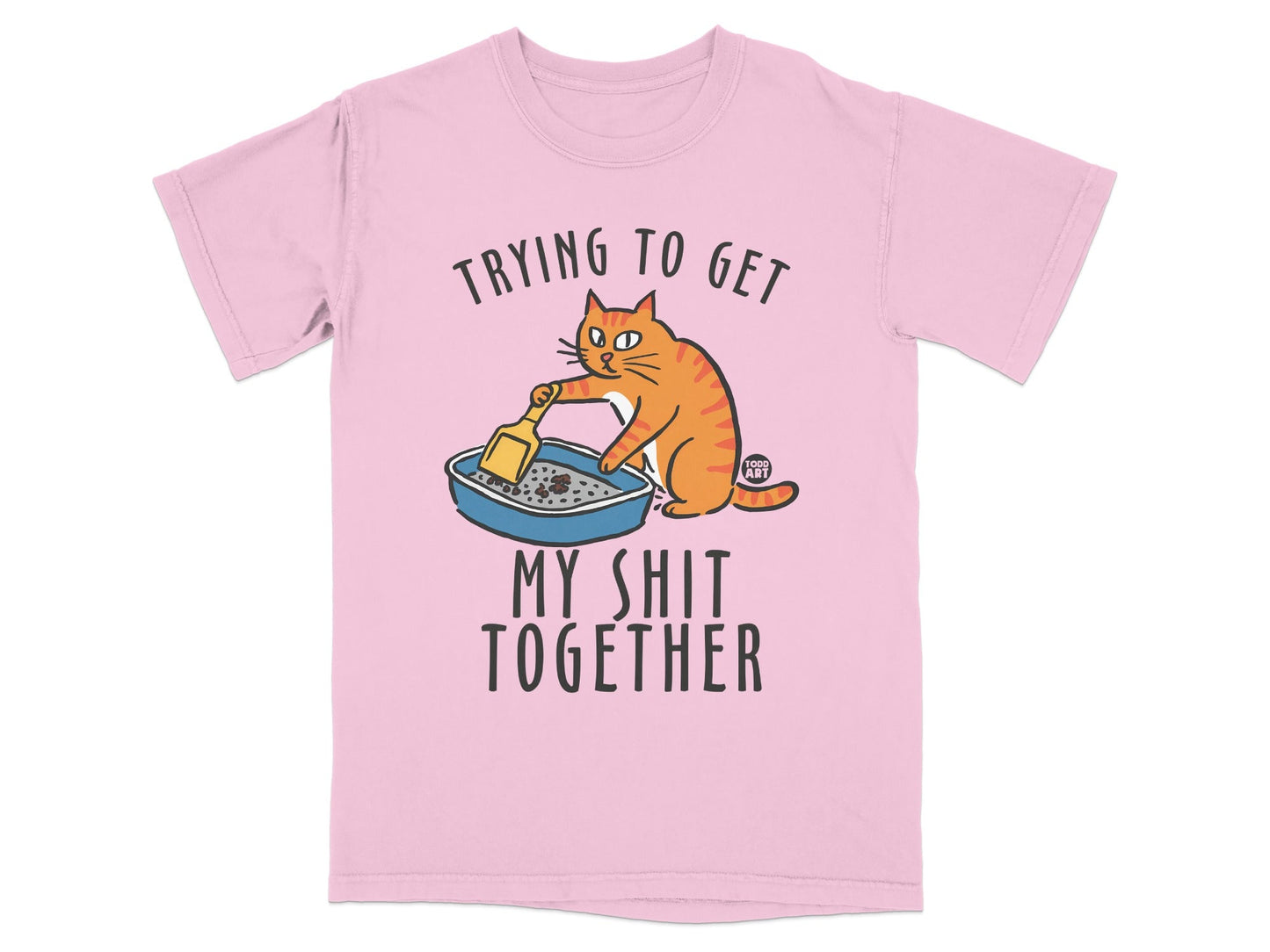 Pink t-shirt with cartoon cat cleaning litter box and text "Trying to get my shit together".