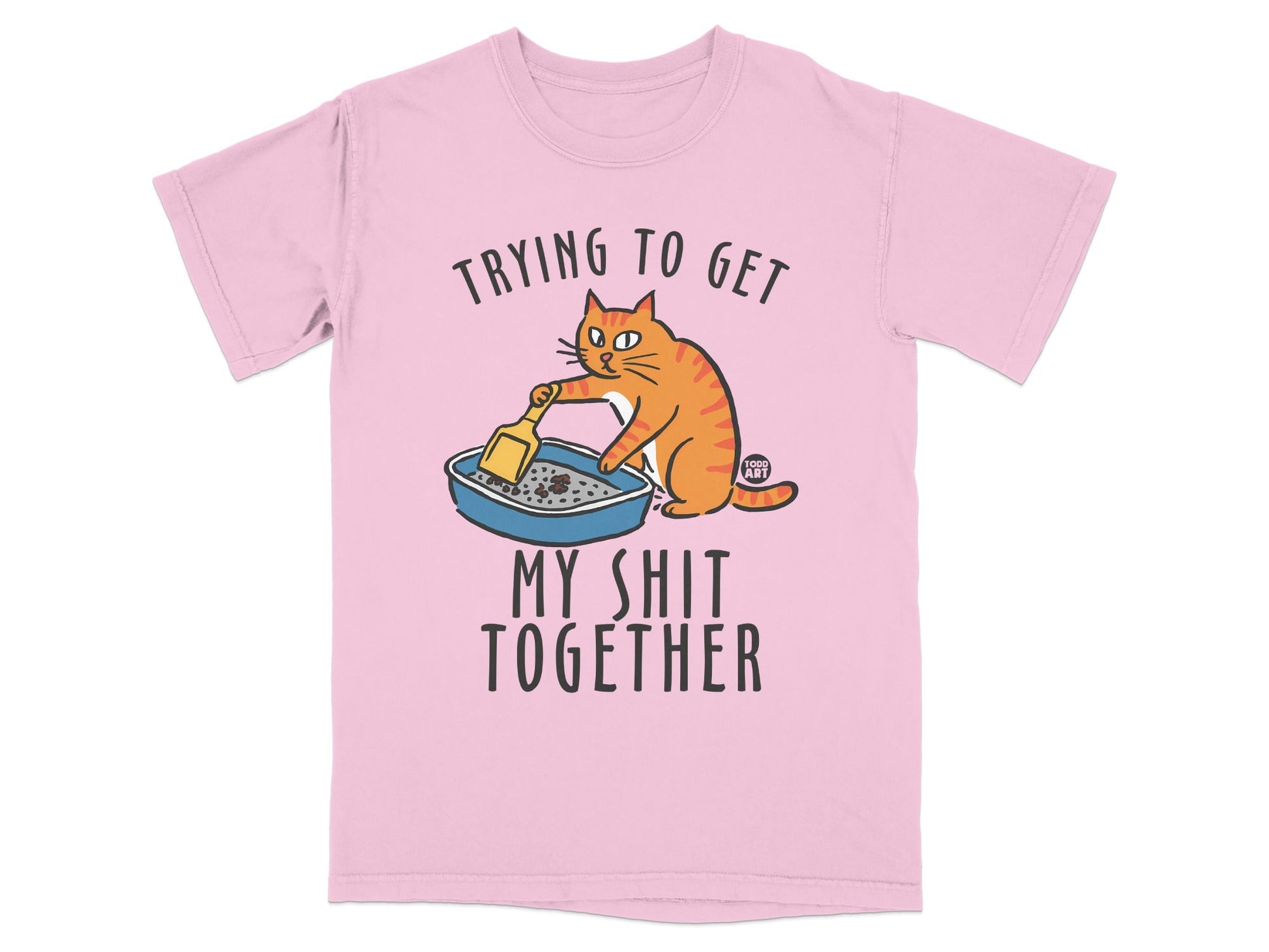 Pink t-shirt with cartoon cat cleaning litter box and text "Trying to get my shit together".