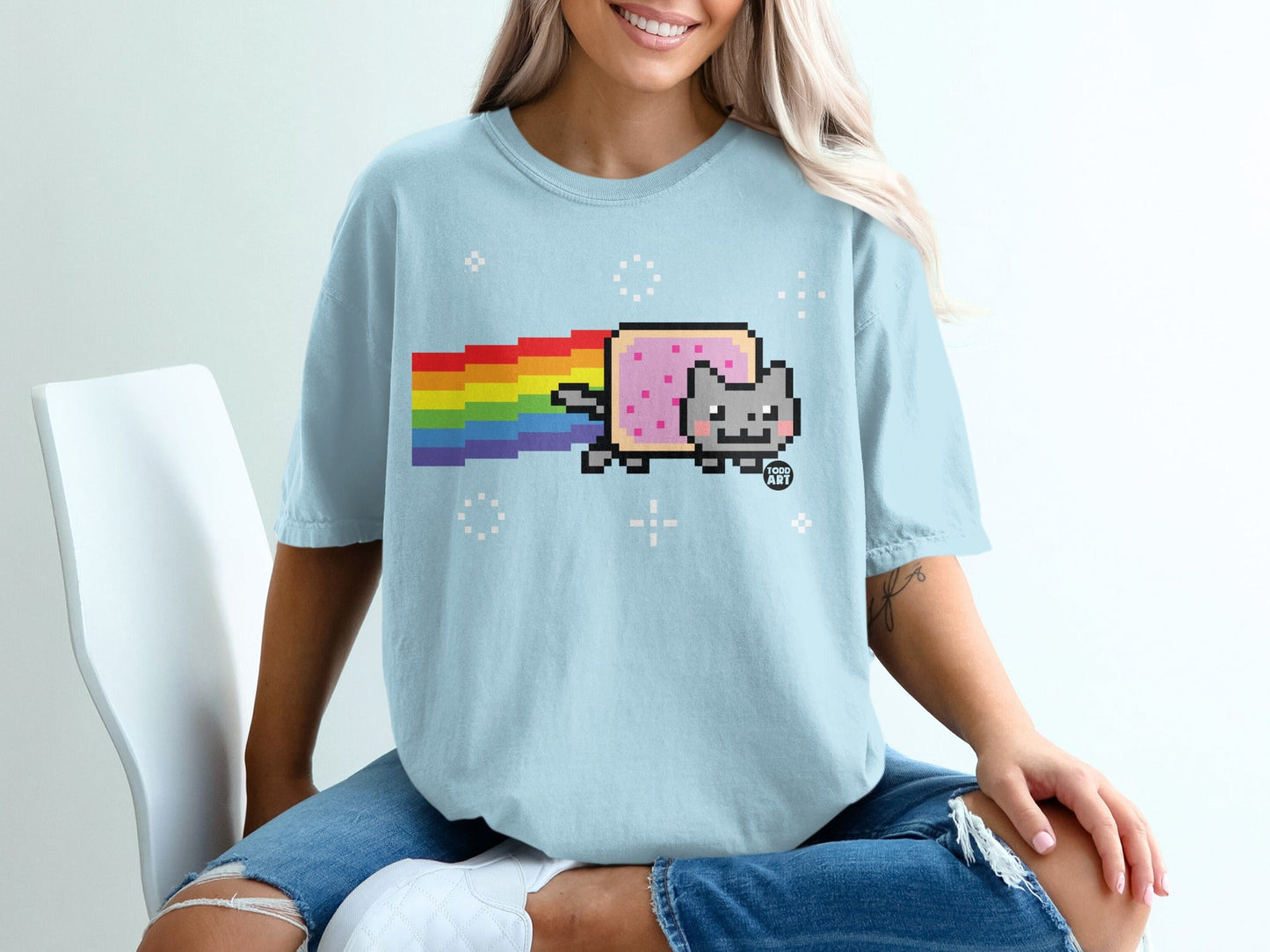 Light blue t-shirt with Nyan Cat, pixelated cat with rainbow trail.
