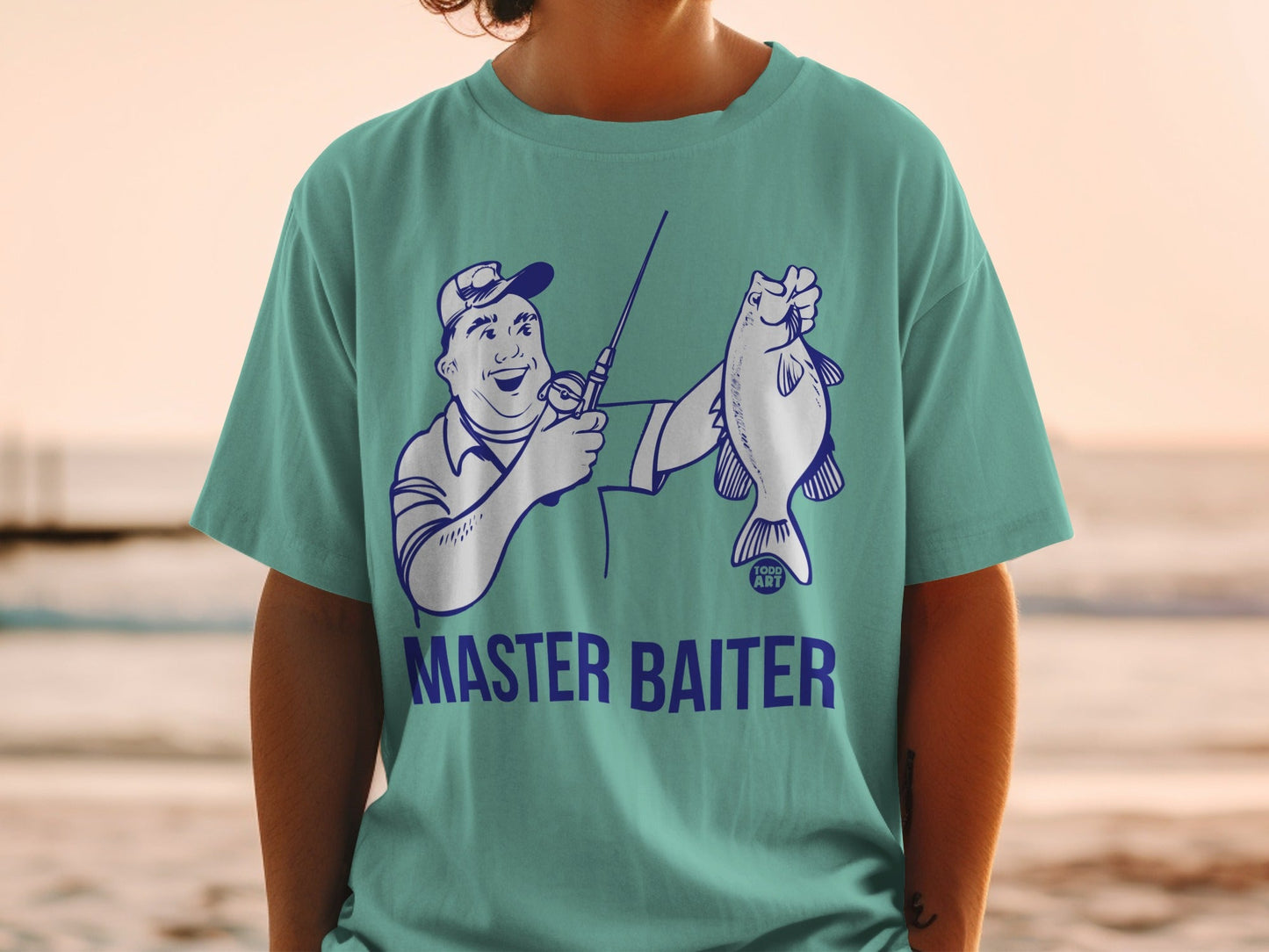 Teal t-shirt with cartoon fisherman holding a fish, text "MASTER BAITER".