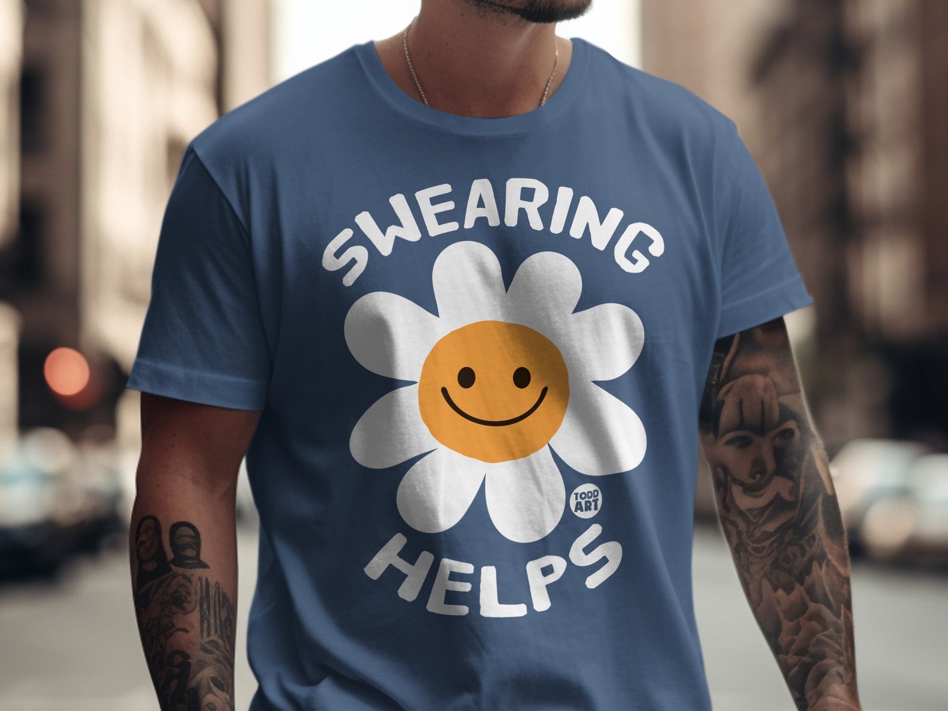 Blue t-shirt with "SWEARING HELPS" and a smiling flower graphic.