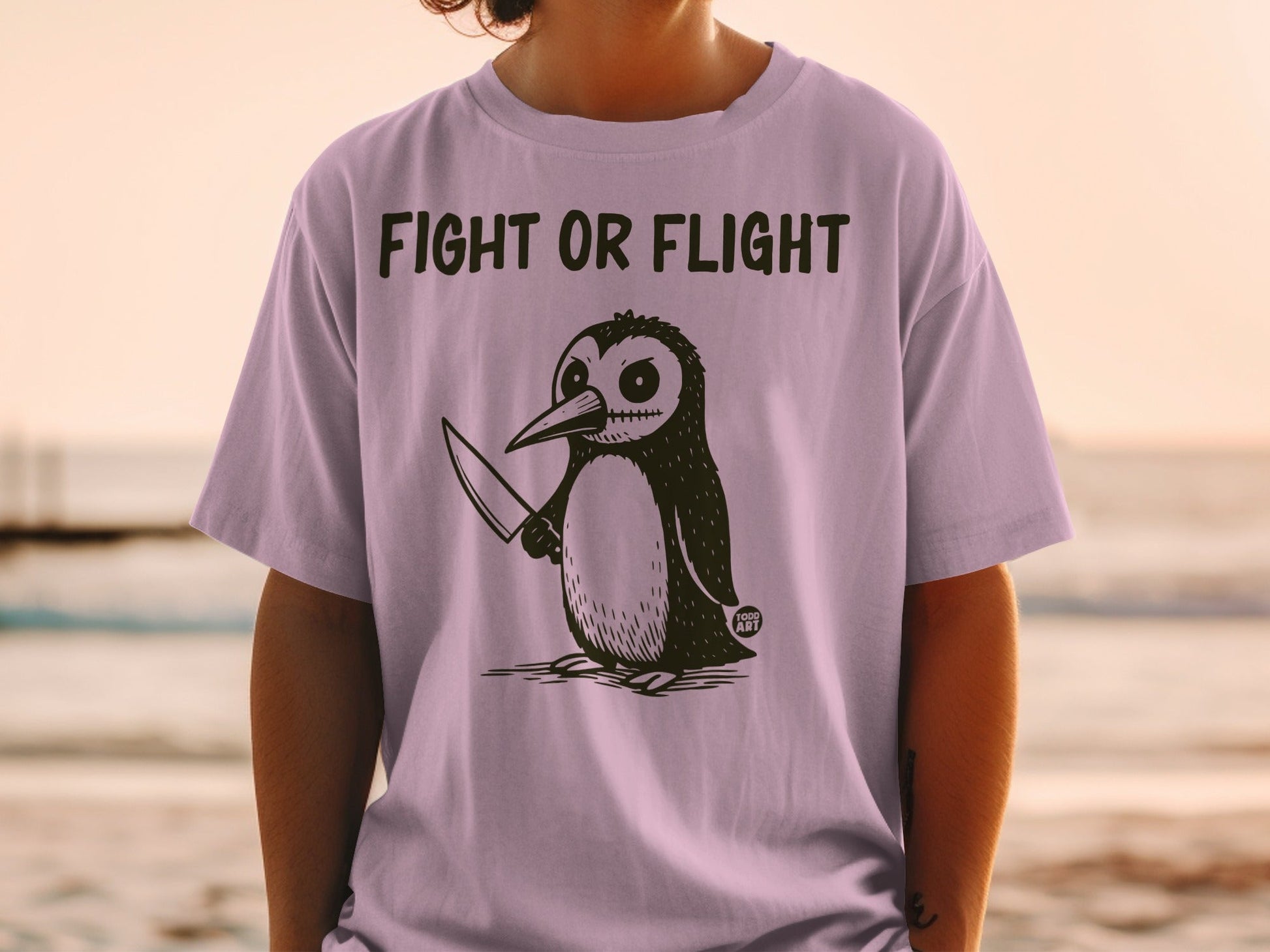 T-shirt with a drawing of a penguin holding a knife.