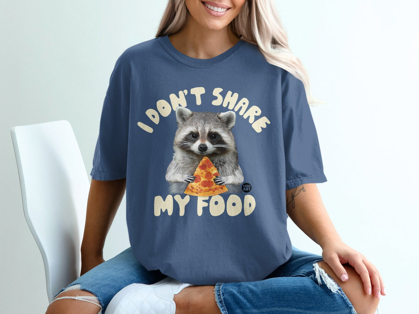 Raccoon in a t-shirt holding a slice of pizza, text "I DON'T SHARE MY FOOD".