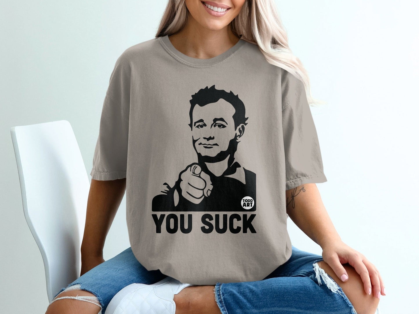 Graphic t-shirt with portrait and "YOU SUCK" text.