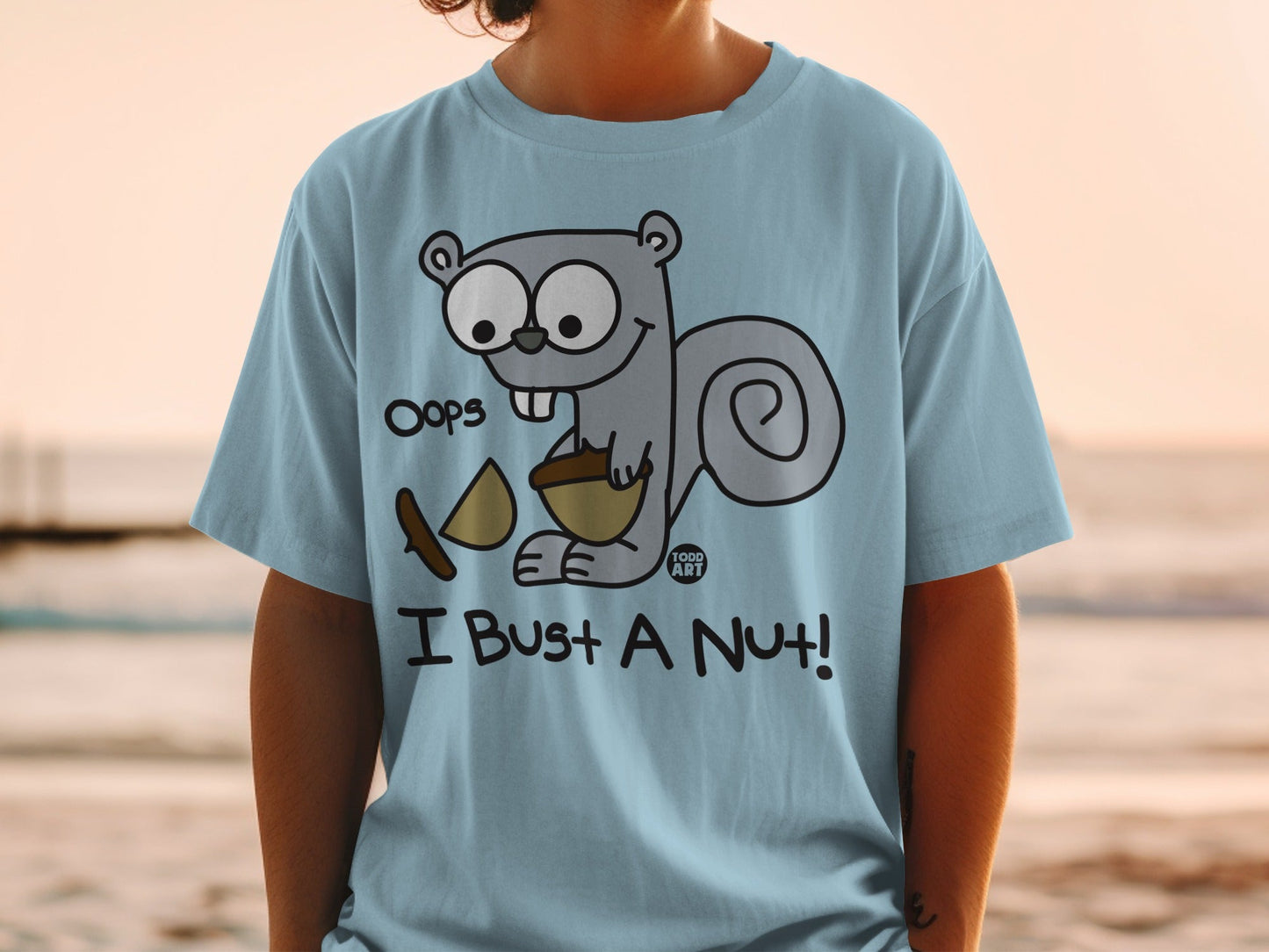 Light blue t-shirt with cartoon squirrel holding a nut and a piece of wood.