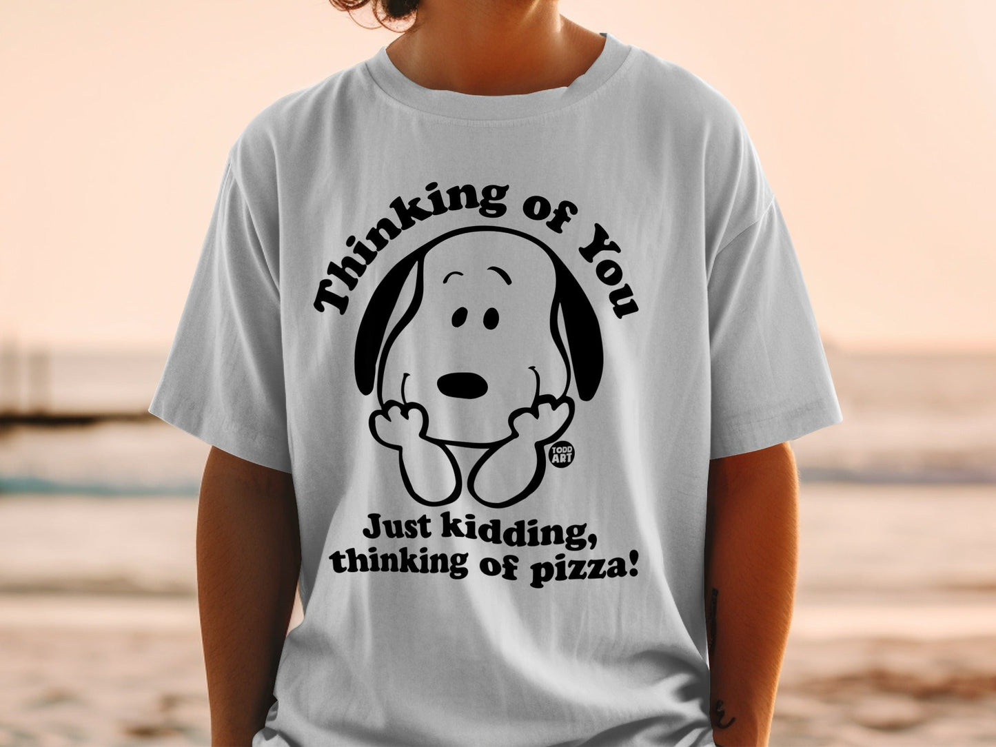 White t-shirt with Snoopy saying "Just kidding, thinking of pizza!"