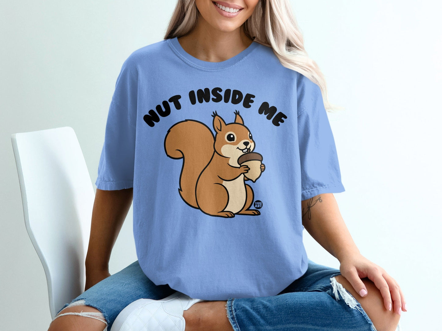 Blue t-shirt with a cartoon squirrel holding an acorn and the text "NUT INSIDE ME".